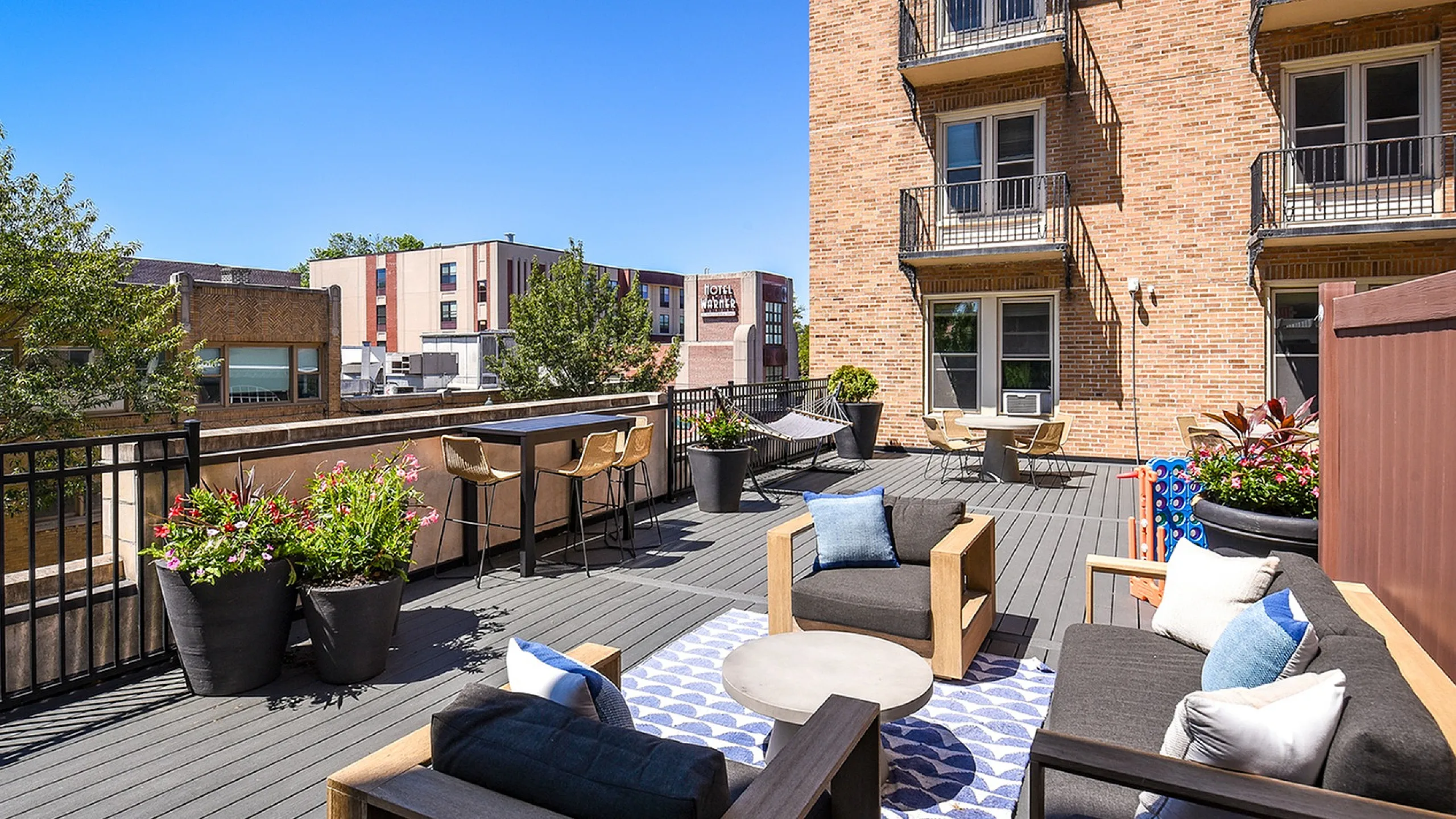 Luxurious urban patio featuring stylish outdoor furniture, vibrant potted plants, and breathtaking city views, perfect for relaxation and entertaining.