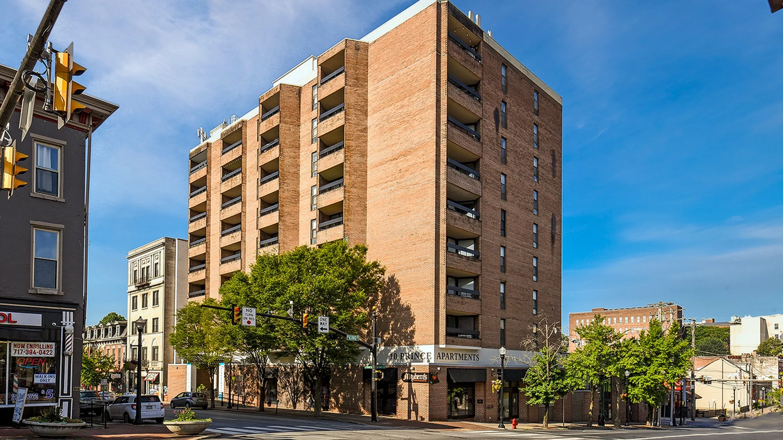 Charming urban apartment building showcasing modern architecture, ample balconies, and a vibrant neighborhood setting.