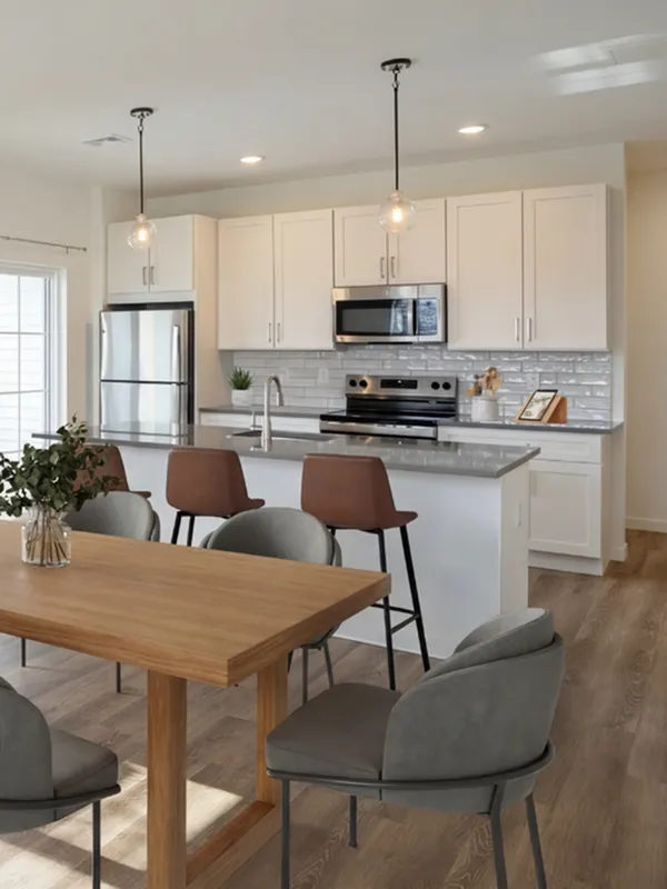 Modern kitchen and dining area with sleek white cabinets, stainless steel appliances, and stylish pendant lighting, creating a welcoming and functional space.