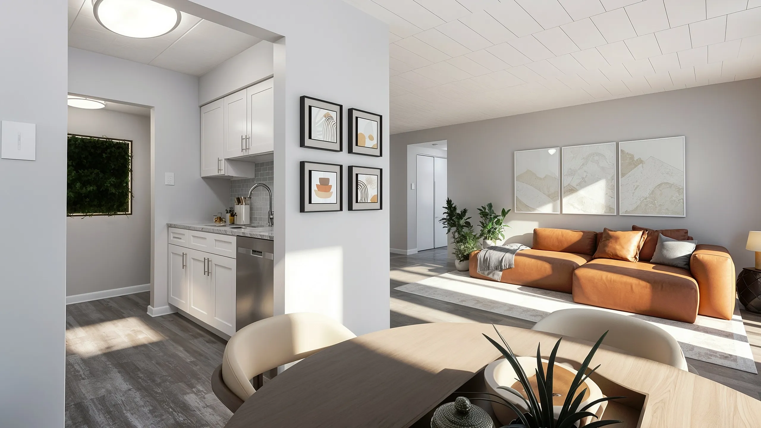 Bright and modern living area with a cozy brown sofa, elegant artwork, and a sleek kitchen featuring white cabinetry. Ideal for stylish urban living.
