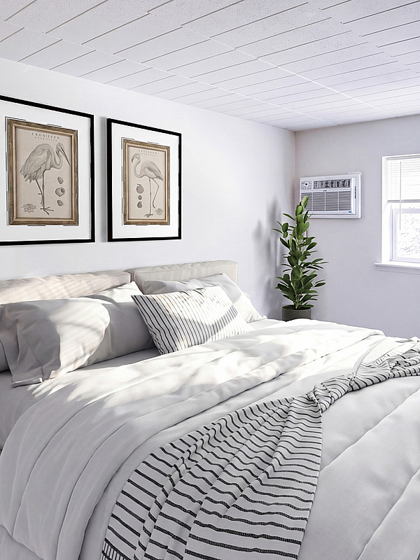 Bright and inviting bedroom with elegant bedding, stylish bedside table, and large window bringing in natural light.