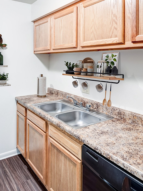 Charming kitchen featuring elegant wooden cabinetry, sleek countertops, and stylish open shelving with decorative accents.