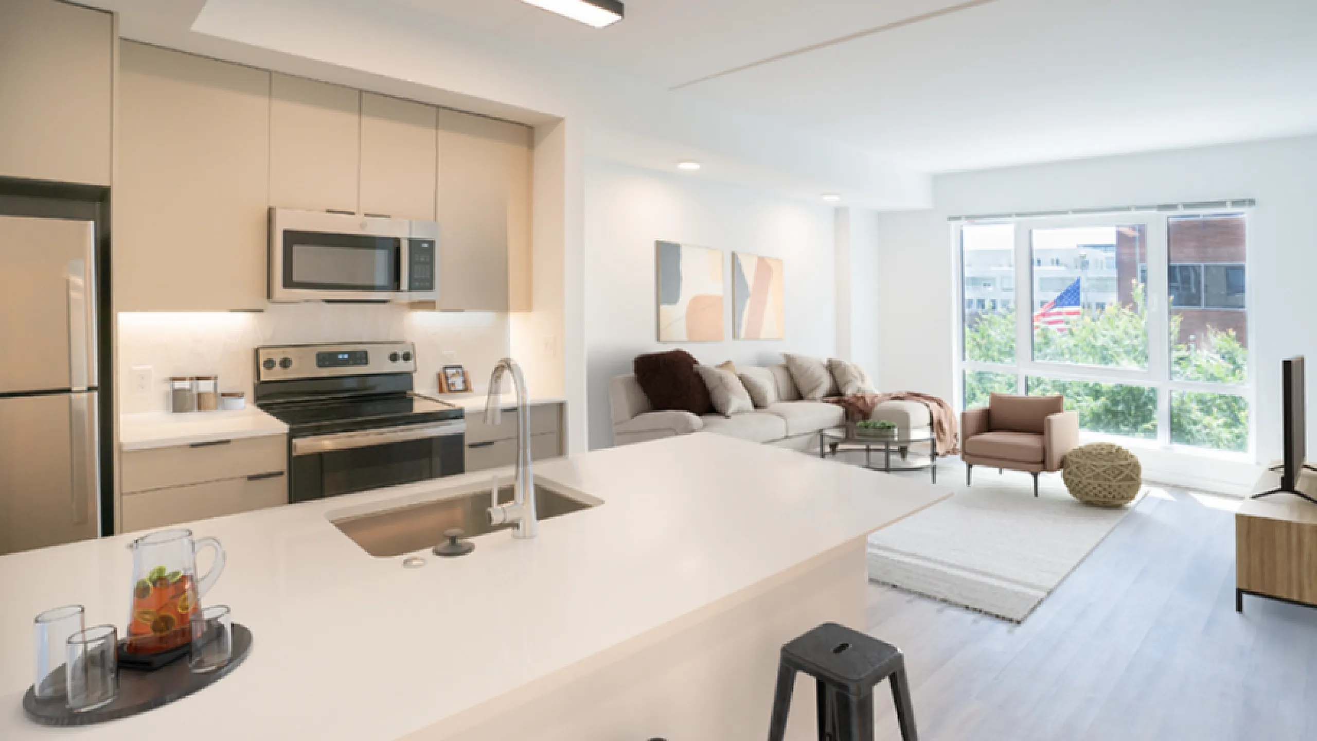 Chic open-plan apartment featuring a modern kitchen with sleek appliances, cozy living room with large windows and abundant natural light.