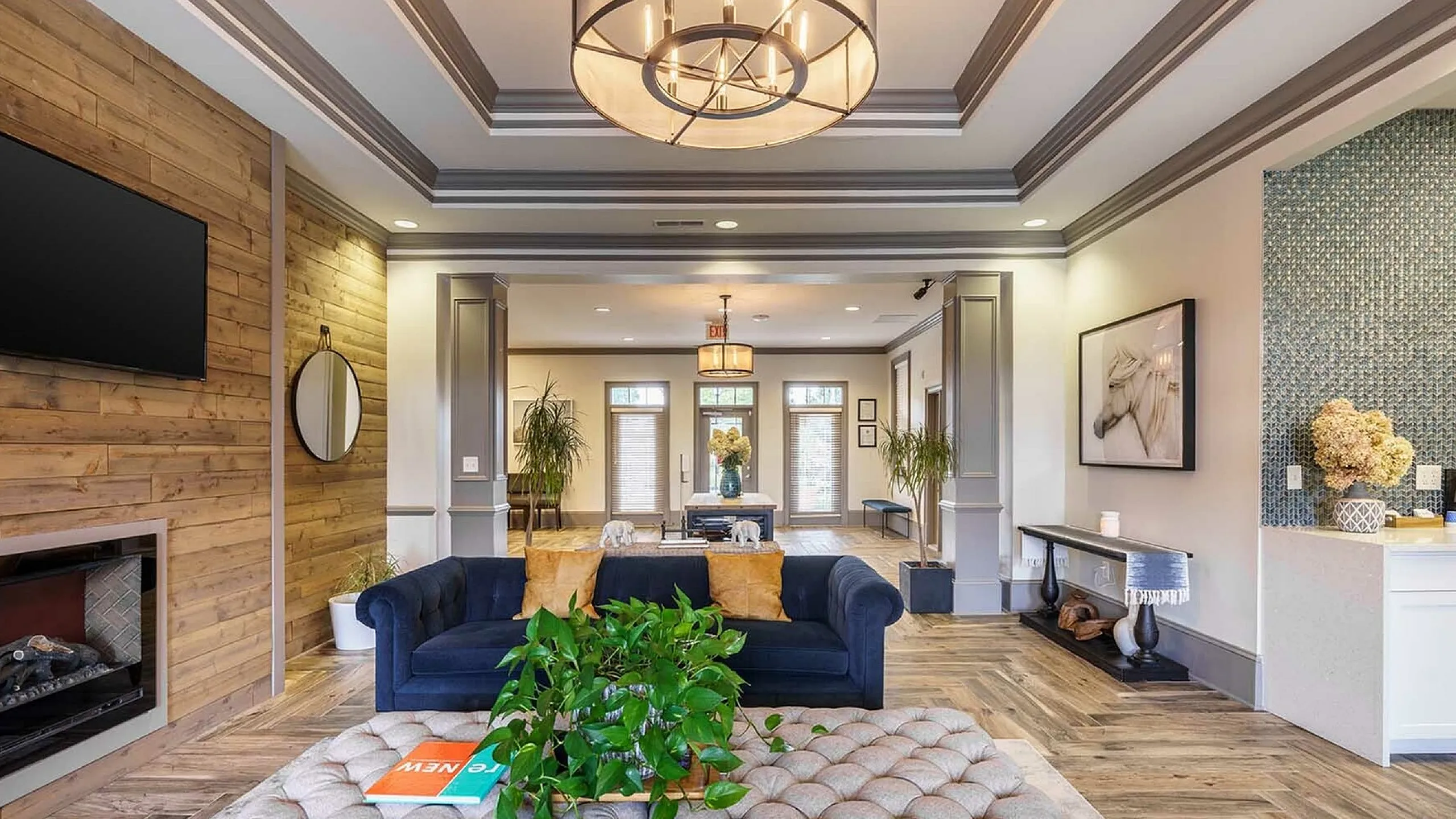 Elegant living room with modern lighting, cozy seating, and stylish wood accents, perfect for relaxation and entertainment.