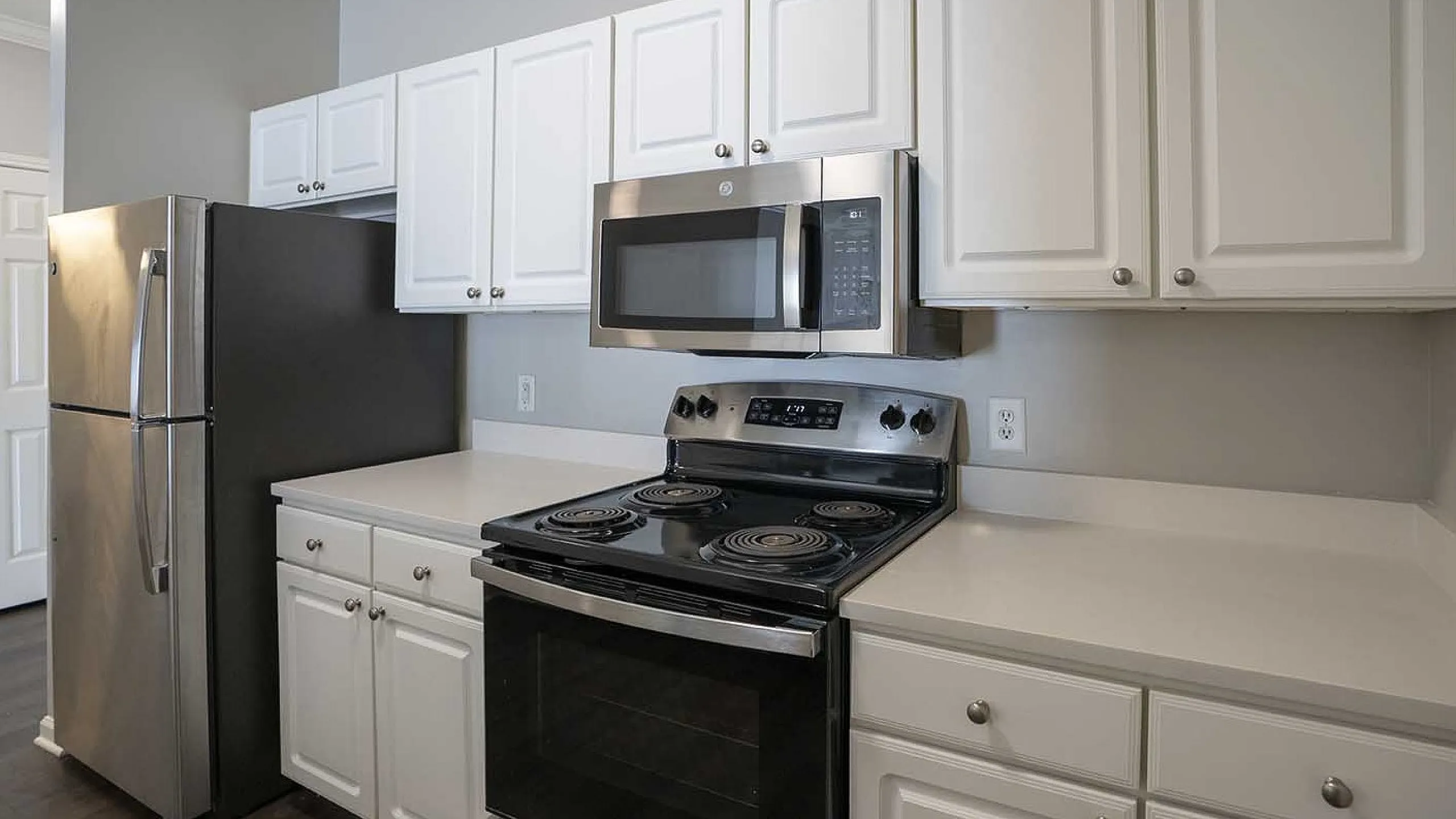 Modern kitchen with sleek stainless steel appliances, elegant white cabinetry, and spacious countertops.