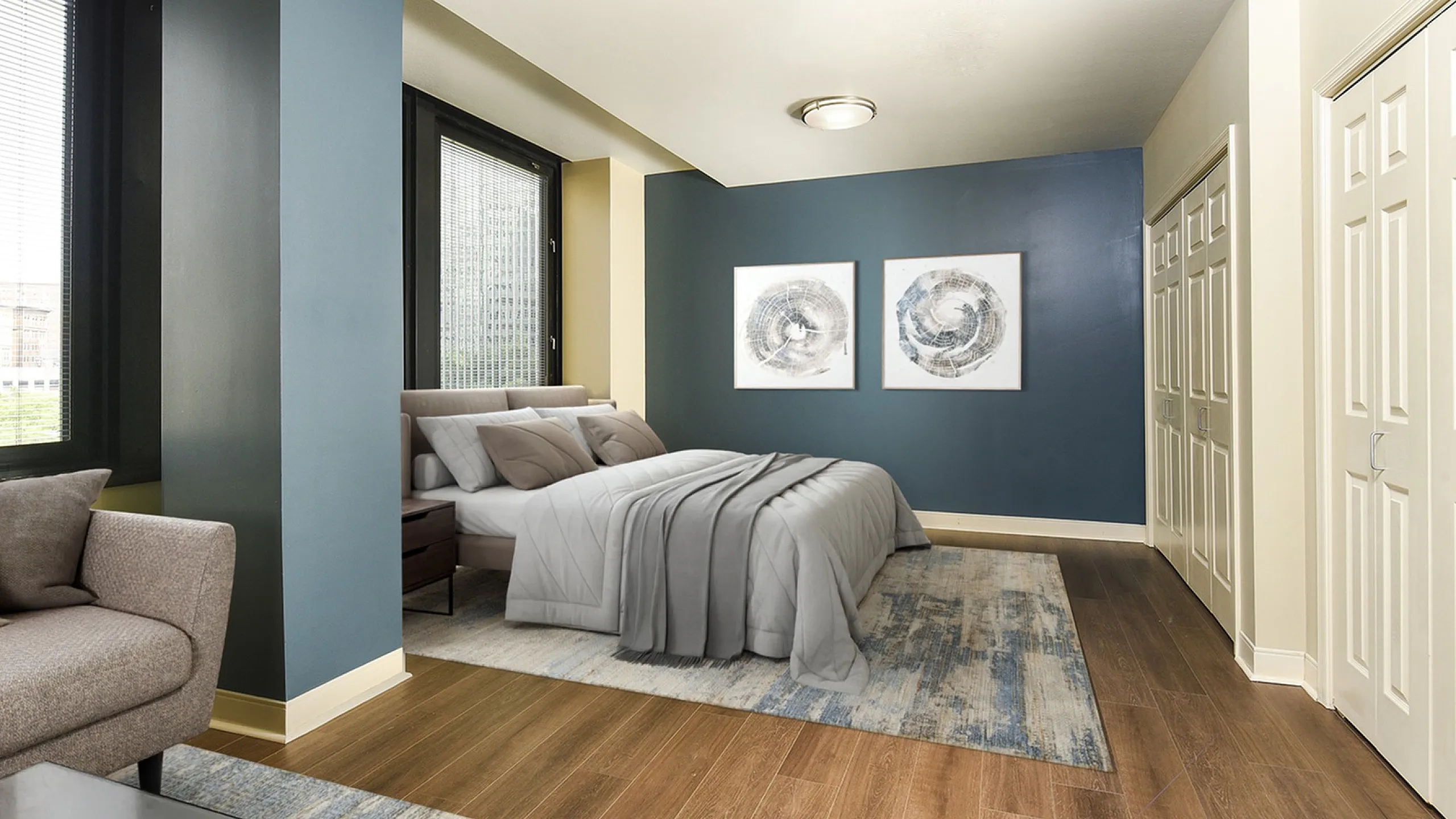 Elegant bedroom with modern decor, featuring plush bedding, stylish artwork, and expansive windows offering natural light.