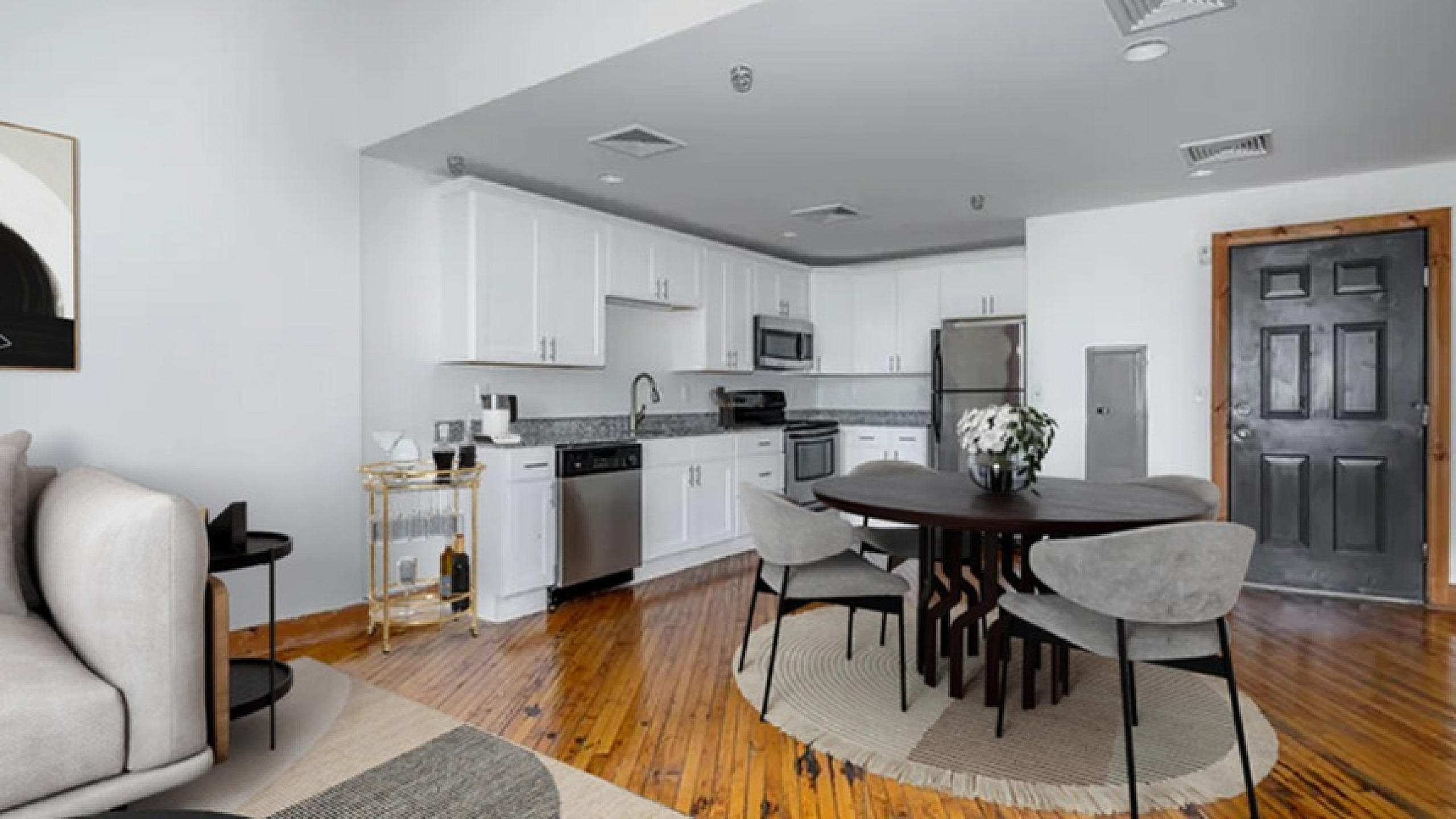 Modern open-concept apartment featuring a sleek kitchen, cozy living area, and elegant dining space with stylish decor.