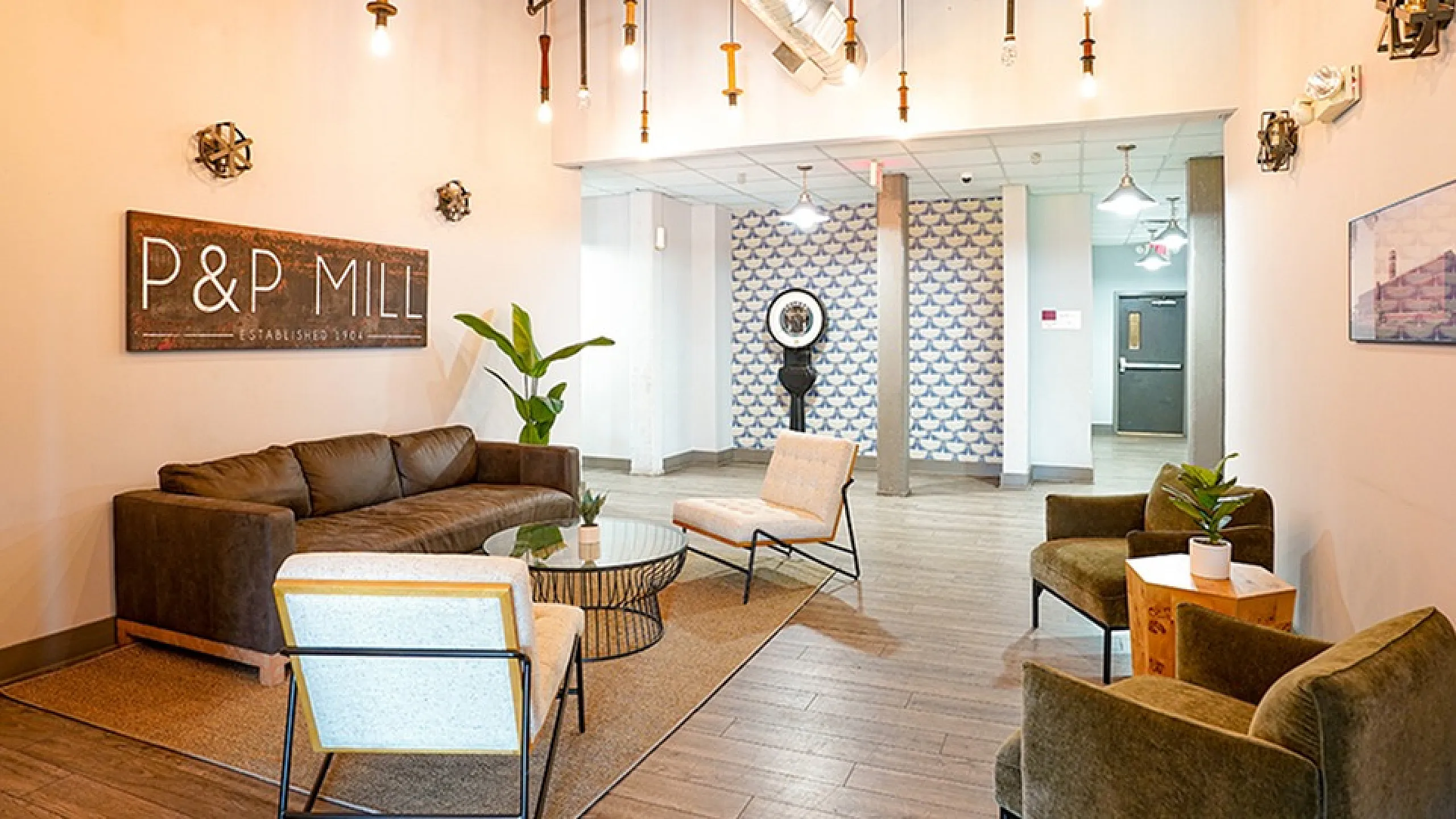 Chic lobby of P&P Mill featuring modern furniture, stylish lighting, and cozy seating area with lush plants.