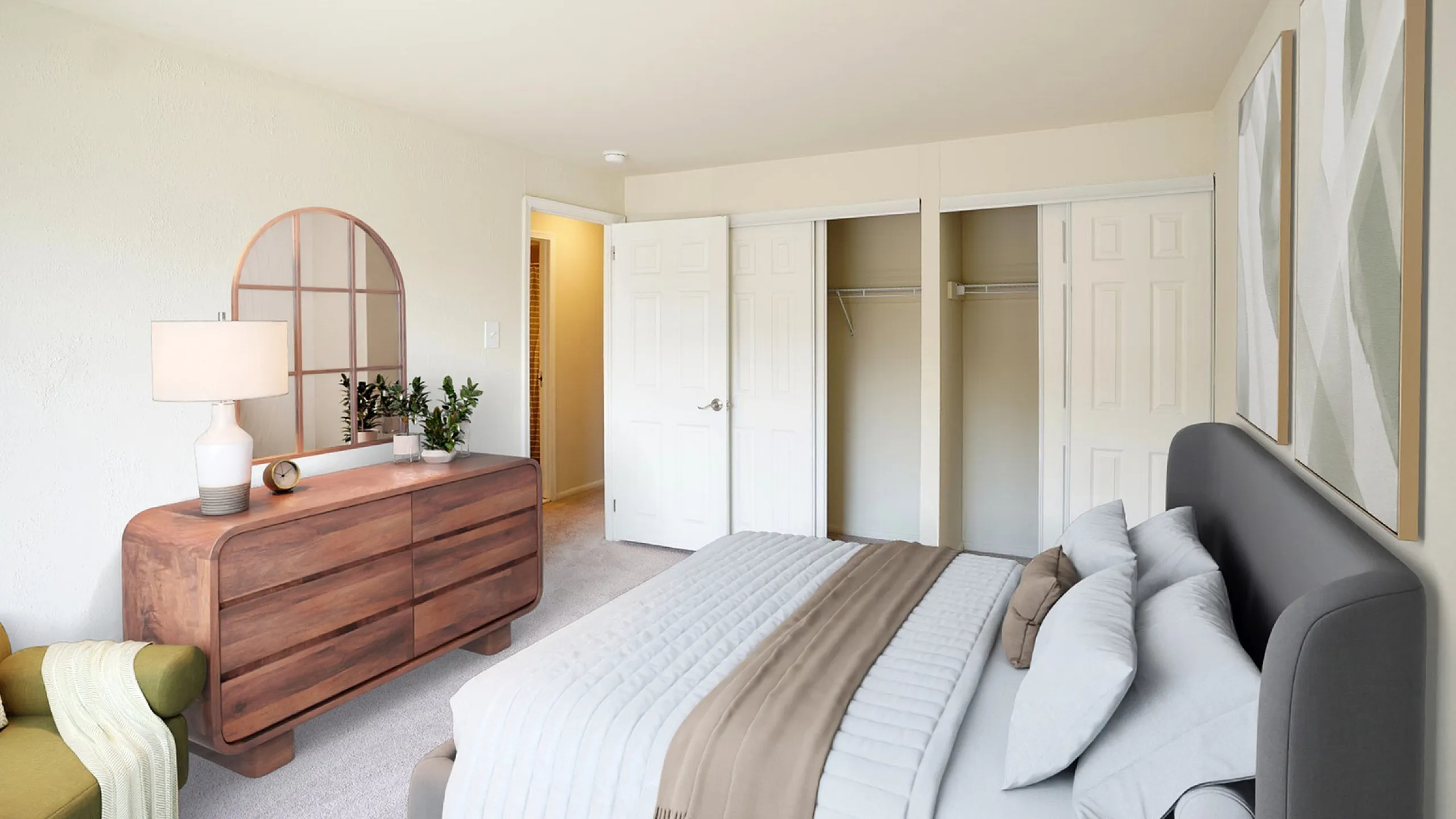 Inviting bedroom with elegant furnishings, featuring a plush bed, chic wooden dresser with a mirror, and a cozy ambiance.