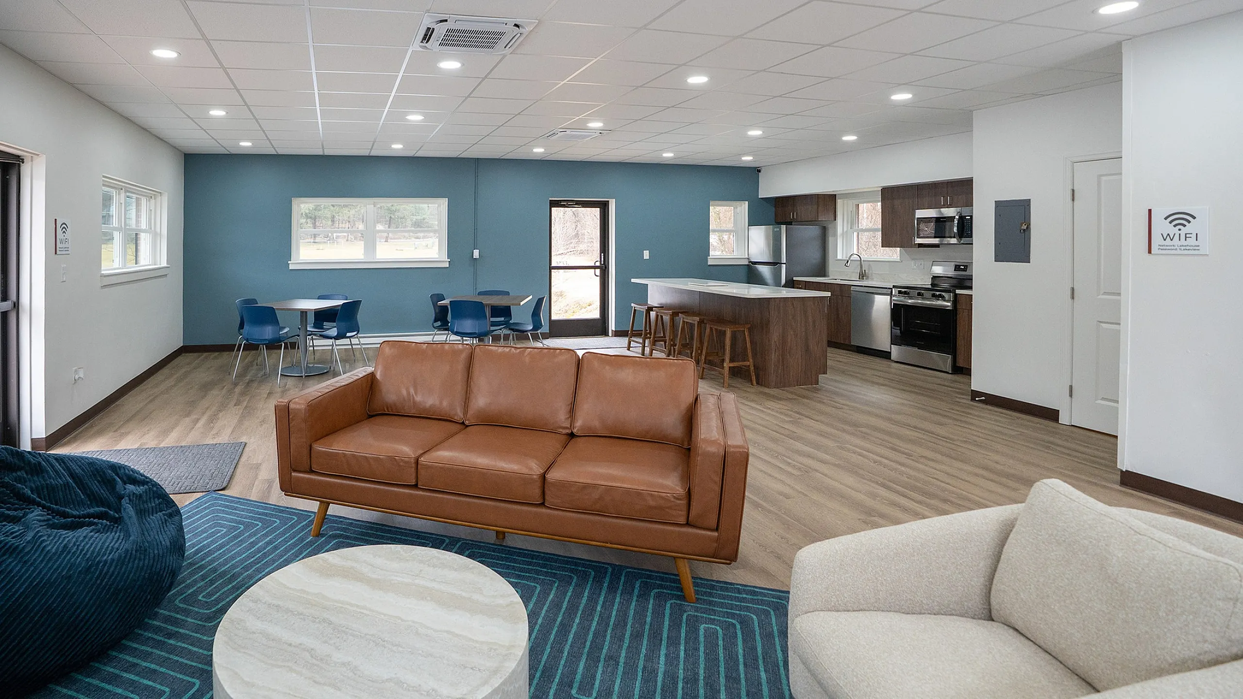 Modern open-concept living area featuring cozy seating, stylish dining space, and a contemporary kitchen with island and stainless steel appliances.