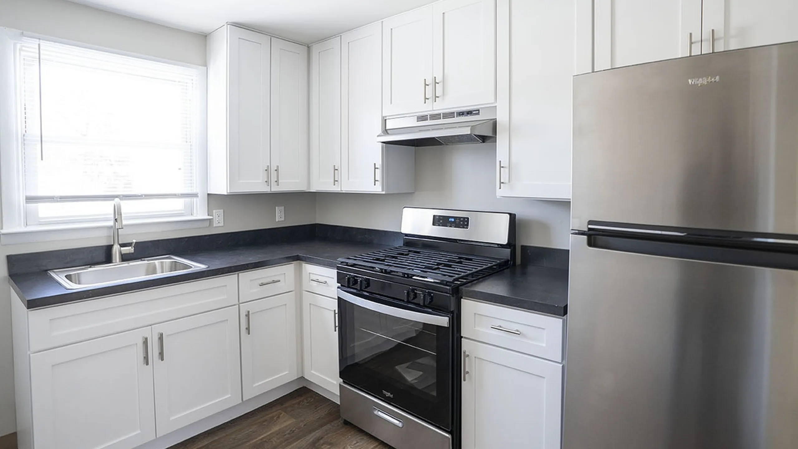 Modern kitchen with sleek white cabinets, stainless steel appliances, and elegant countertops, offering a bright, contemporary feel.