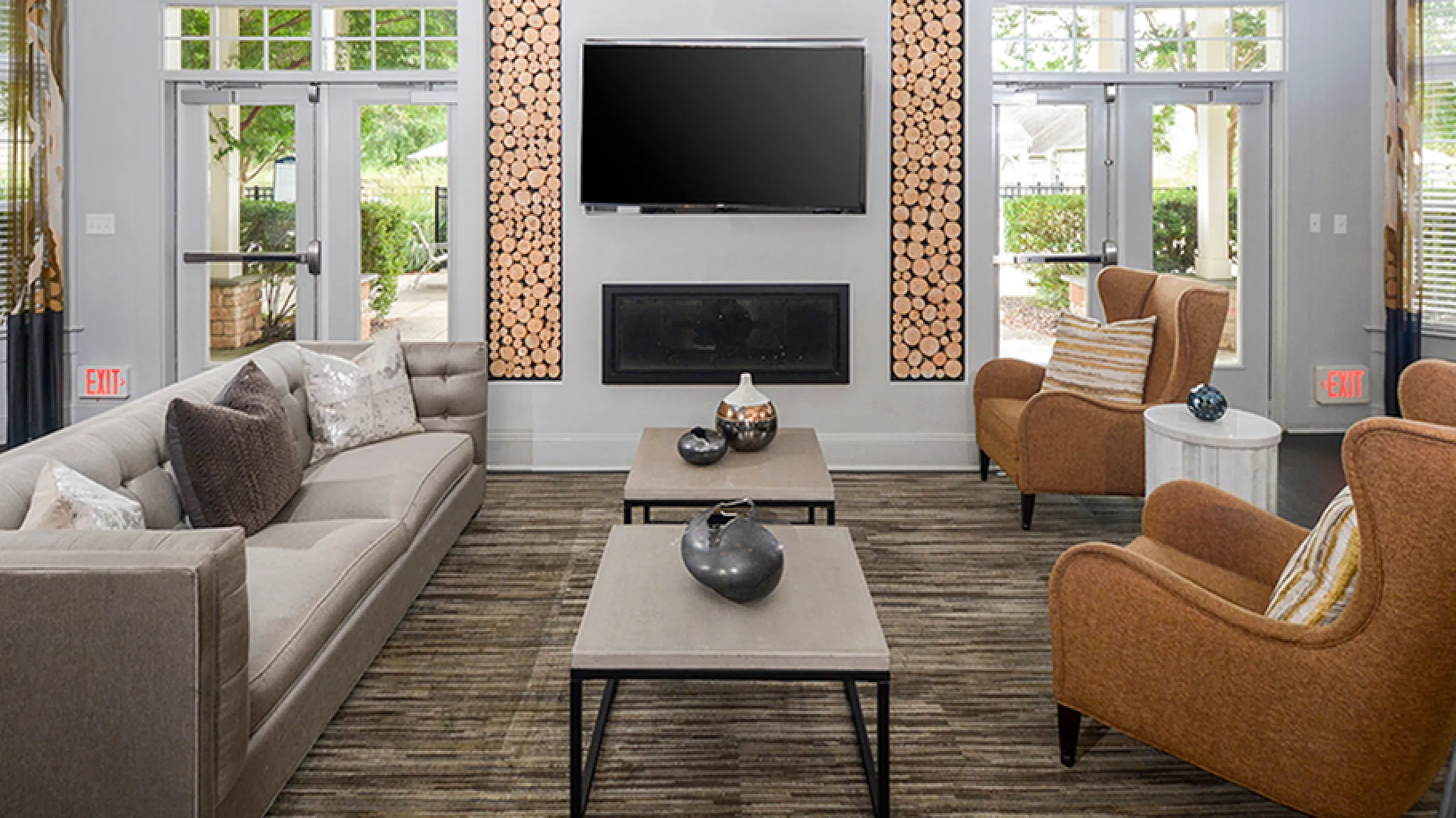 Inviting living room featuring elegant decor, a plush sofa, stylish armchairs, and a modern fireplace with log accents.