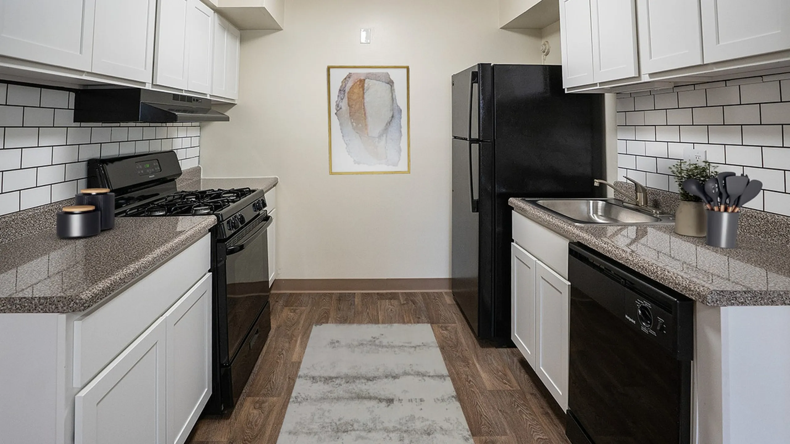Modern kitchen with sleek cabinetry, granite countertops, and stainless steel appliances, highlighting a stylish, open design.
