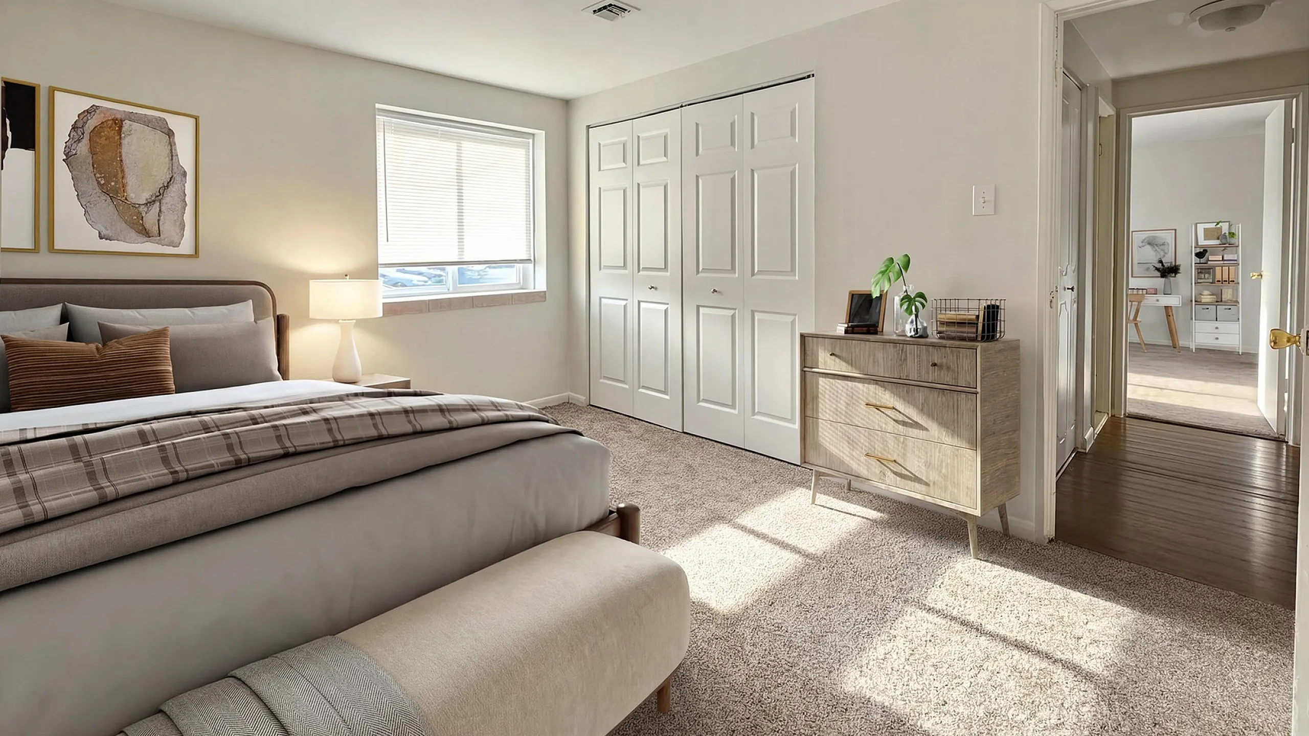 Inviting bedroom with plush carpeting, stylish bedding, and natural light. Features elegant d&eacute;cor and a view into a spacious, well-lit hallway.