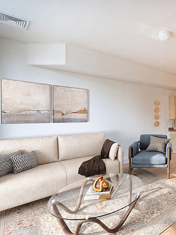 Modern open-concept living space with sleek kitchen, stylish furniture, and elegant staircase, bathed in natural light.