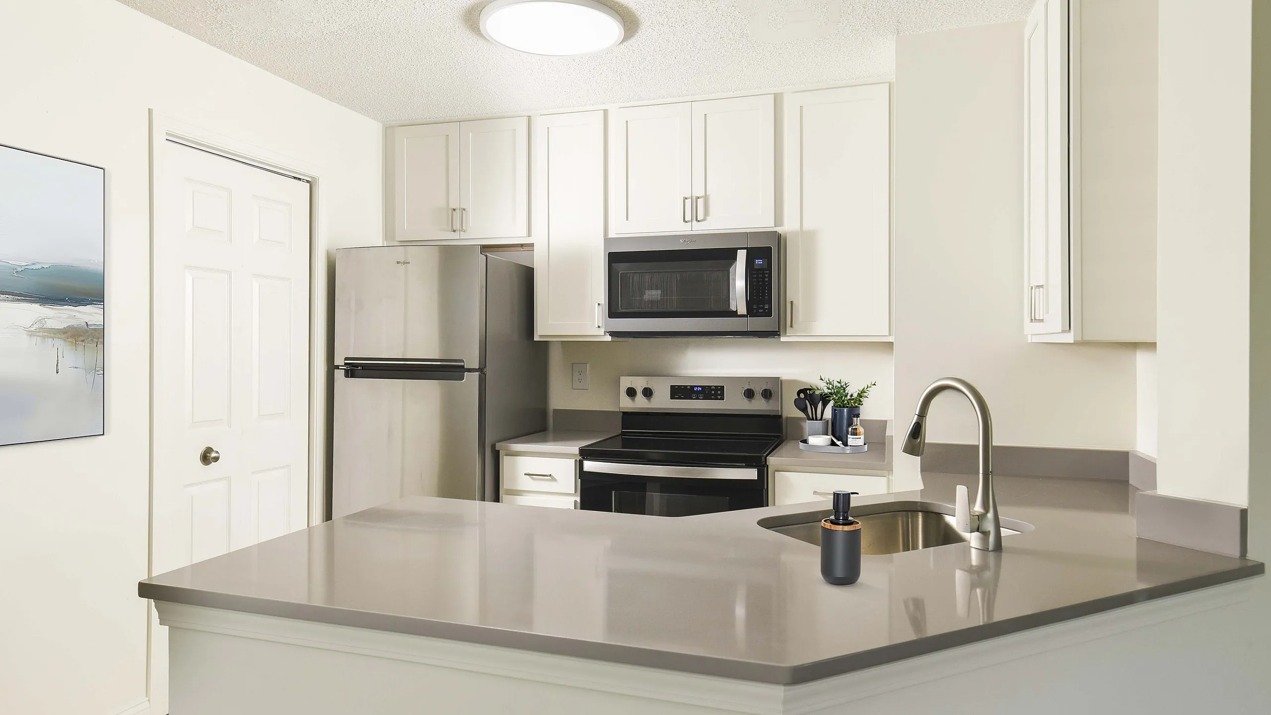Modern kitchen with sleek appliances, a stainless steel refrigerator, and minimalist countertops, exuding a sophisticated ambiance.