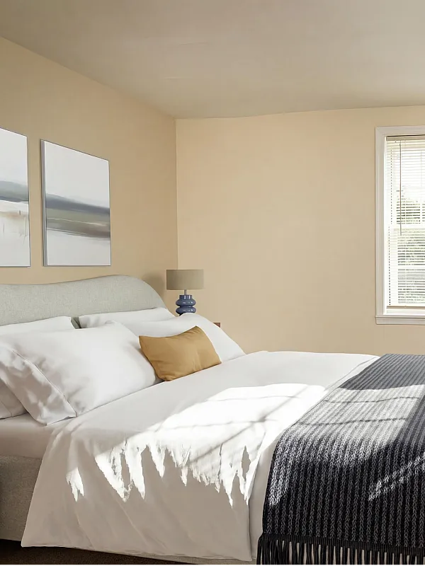 Bright and airy bedroom with a stylish bed, chic wooden dresser, and inviting natural light.