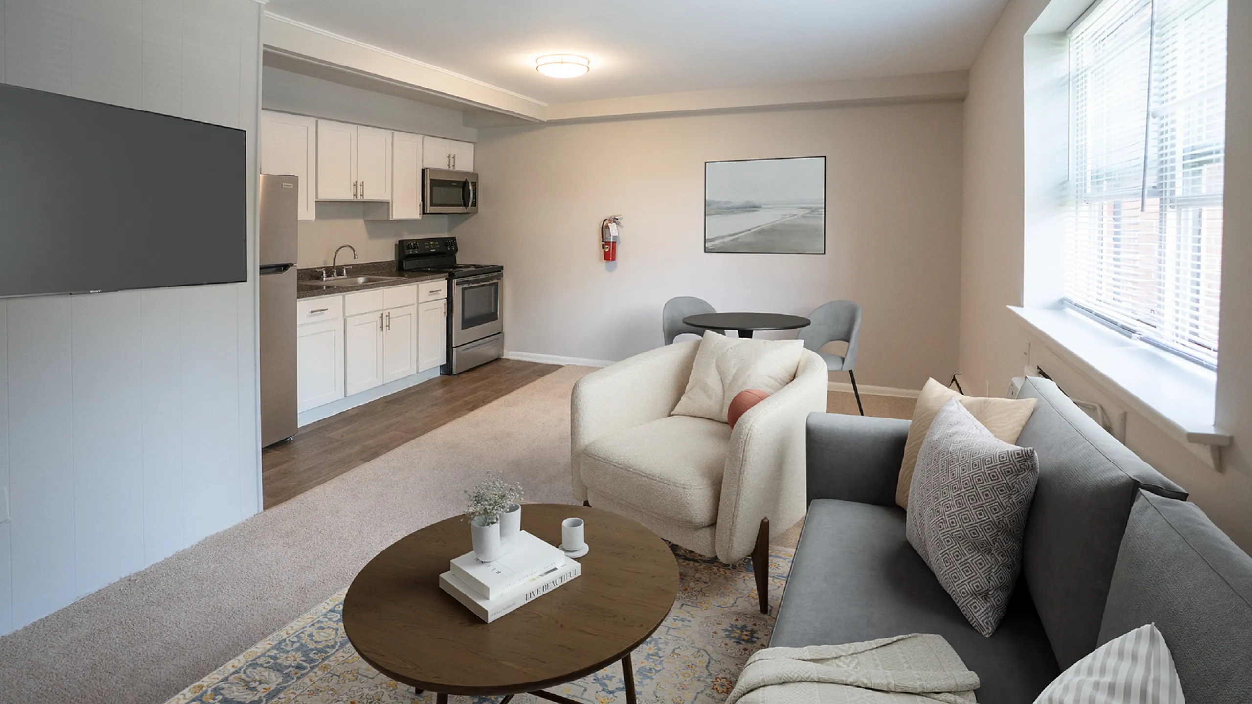 Contemporary open-concept living space with a modern kitchen, chic seating area, and ample natural light.