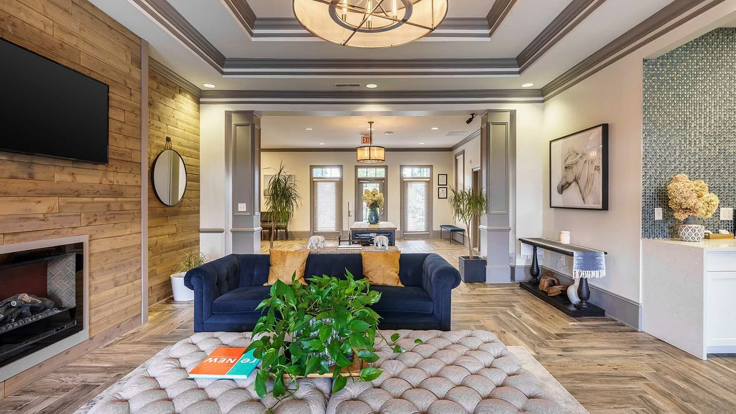 Elegant apartment living room with stylish chandelier, cozy fireplace, and sophisticated decor.