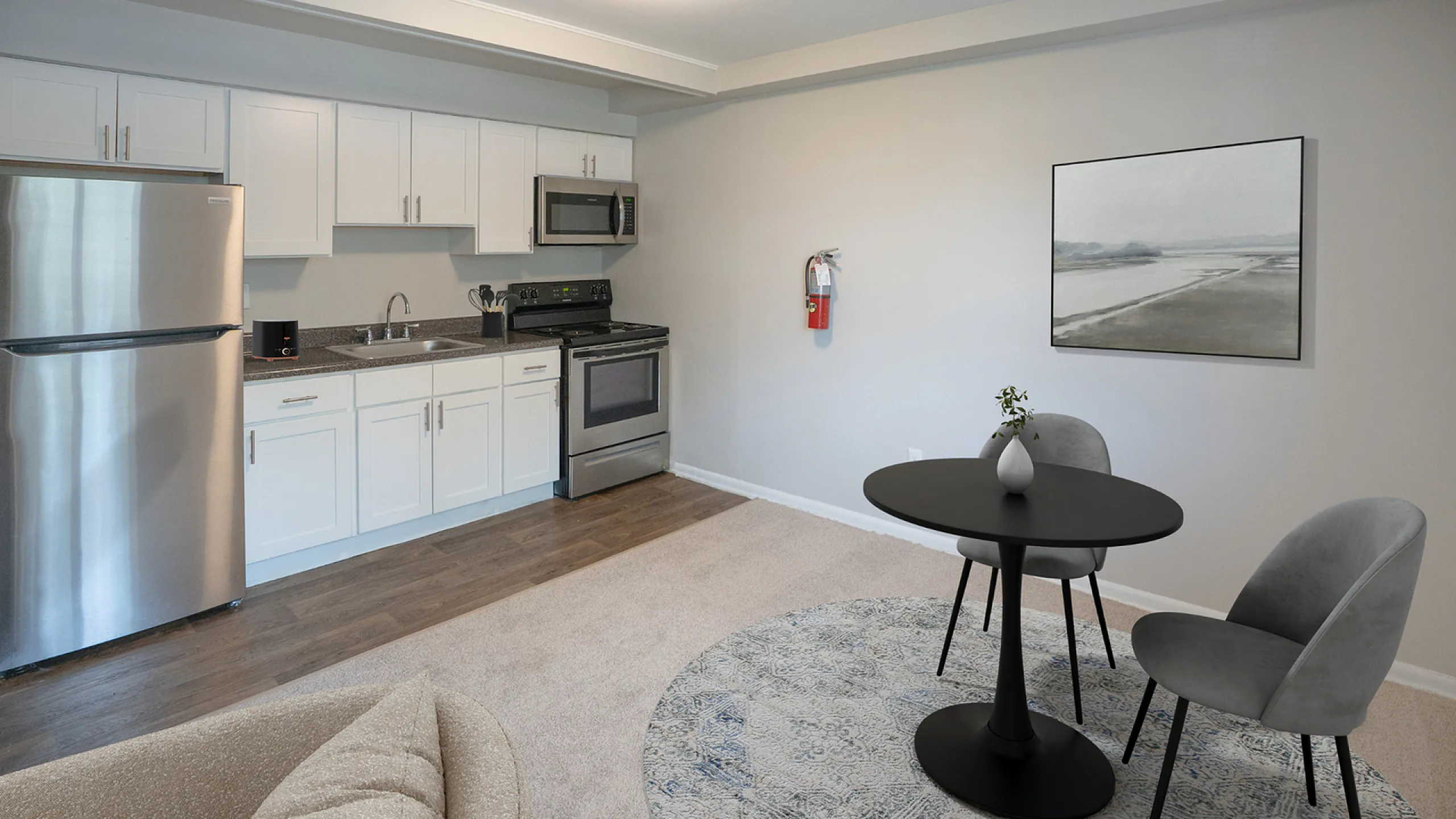 Modern open-plan kitchen and dining area with sleek stainless steel appliances and elegant furnishings.
