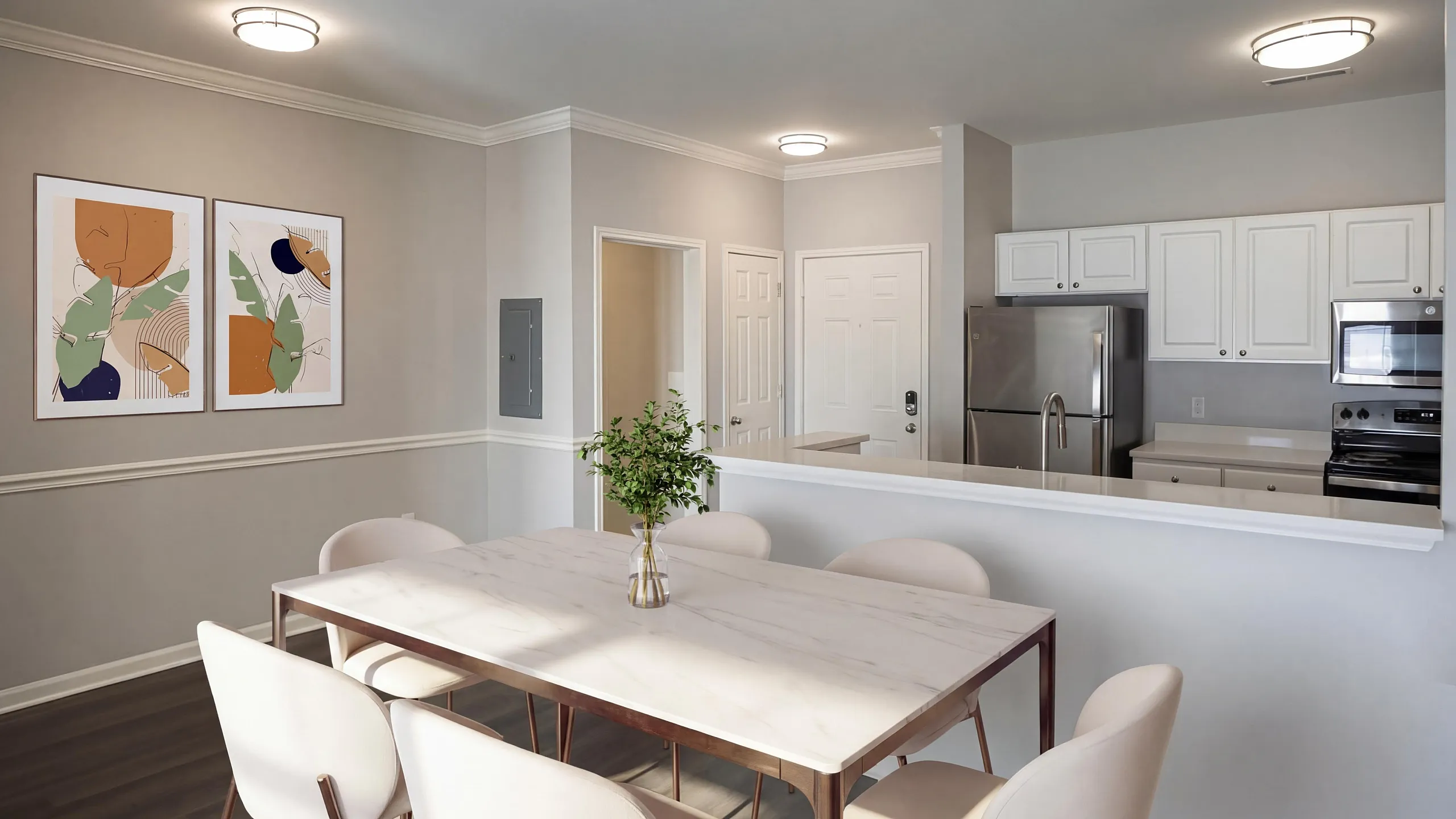 Bright and modern dining area with elegant table, art on walls, and sleek open kitchen.
