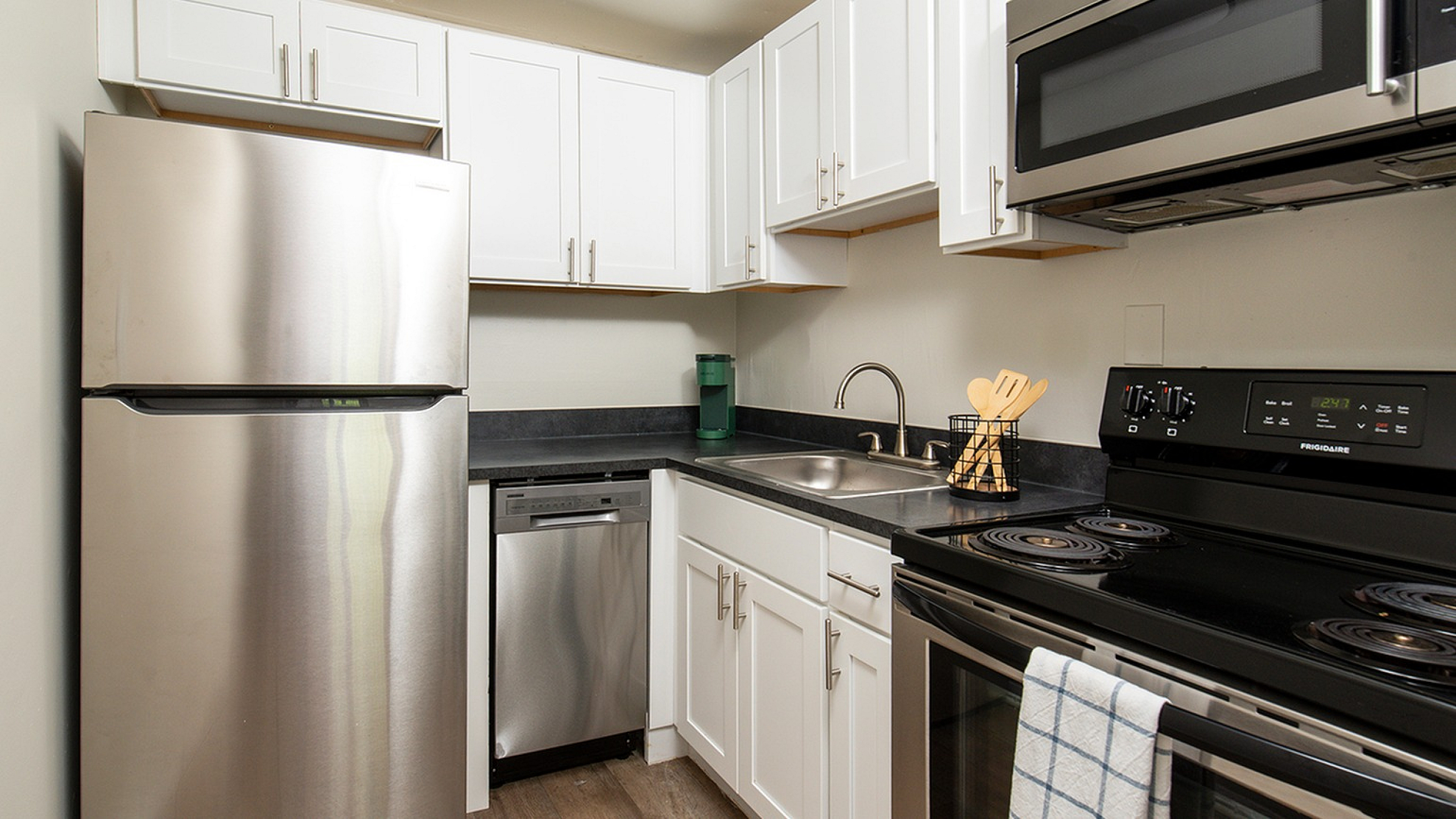Modern kitchen with sleek stainless steel appliances, white cabinetry, and elegant countertops, offering a stylish and functional cooking space.