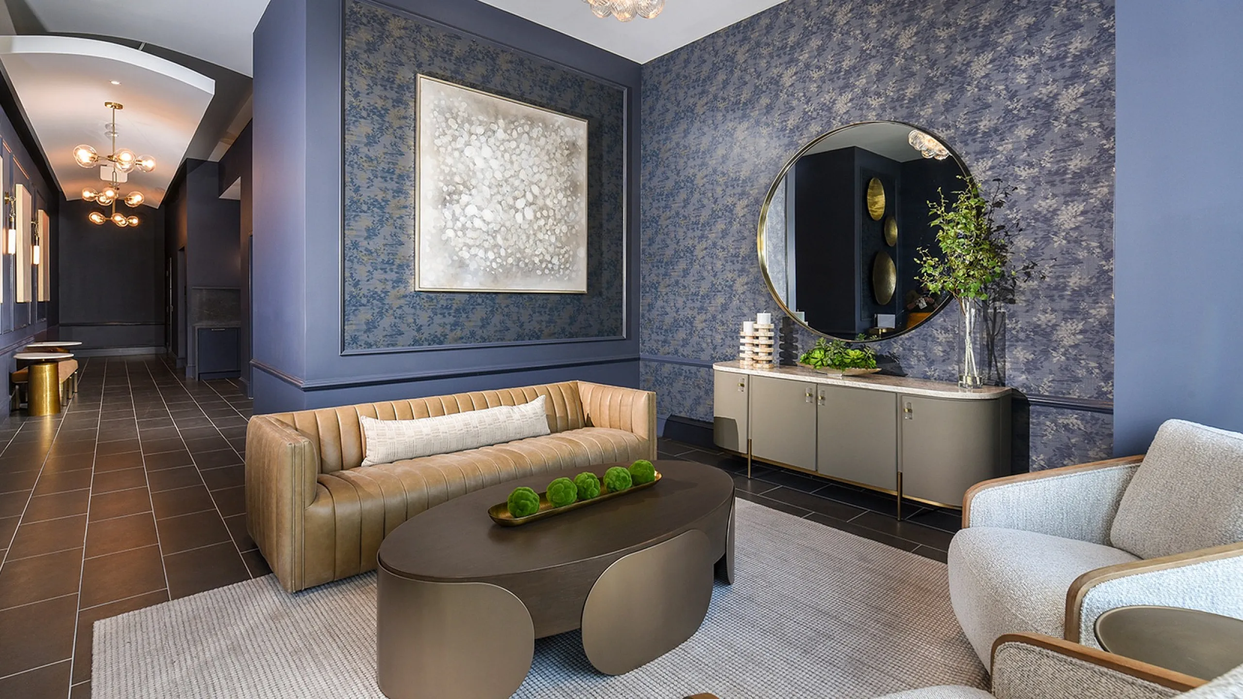Elegant living room with chic beige and blue color scheme, featuring a modern chandelier, stylish sofa, and sophisticated wall art.