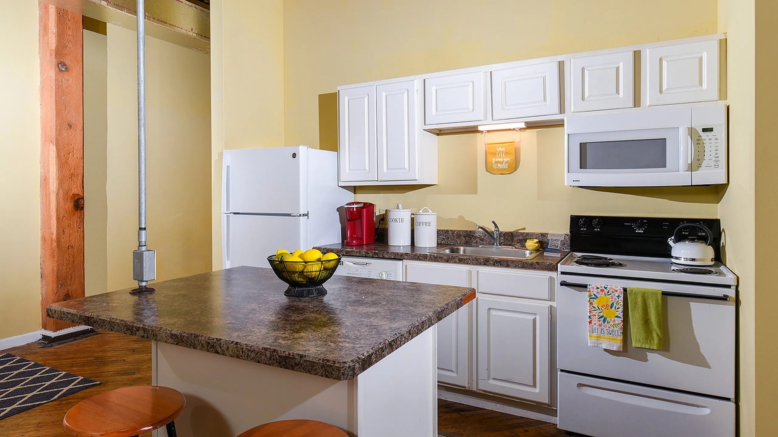 Charming kitchen with modern appliances, a cozy island with seating, and a warm, inviting ambiance.