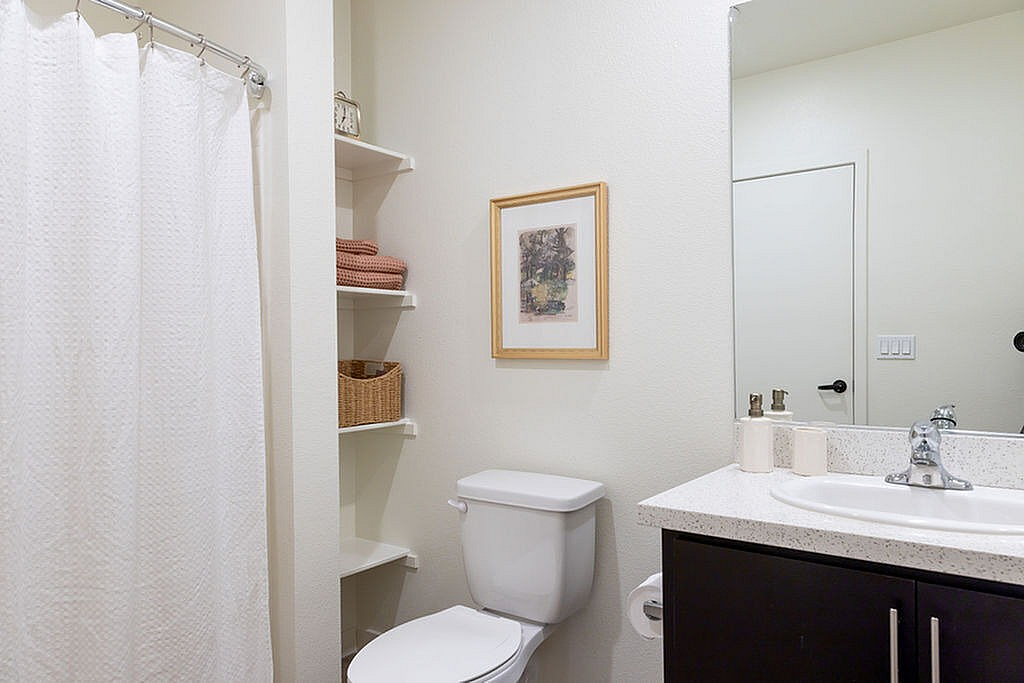 Bright, modern bathroom with elegant fixtures, spacious shelving, and tasteful decor.