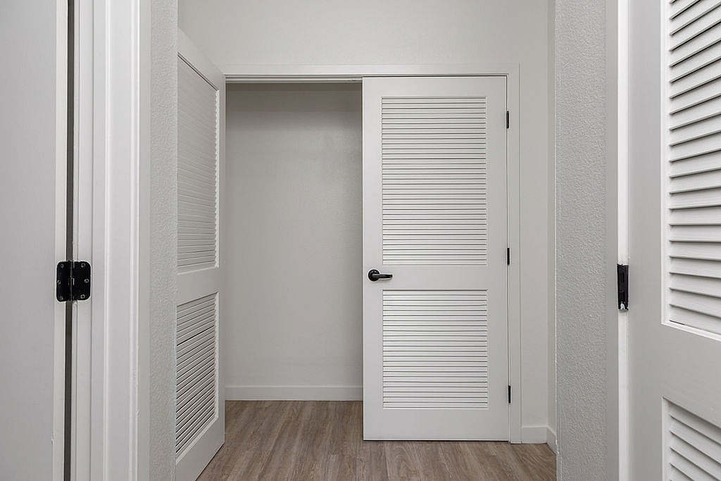 Interior storage with modern shutter-style doors, showcasing a sophisticated design and light wood flooring.