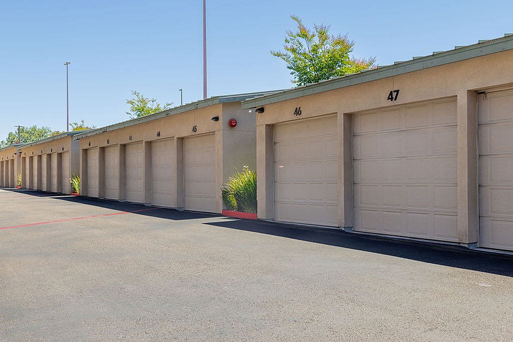 Secure garages featuring remote open and close doors under a clear blue sky.