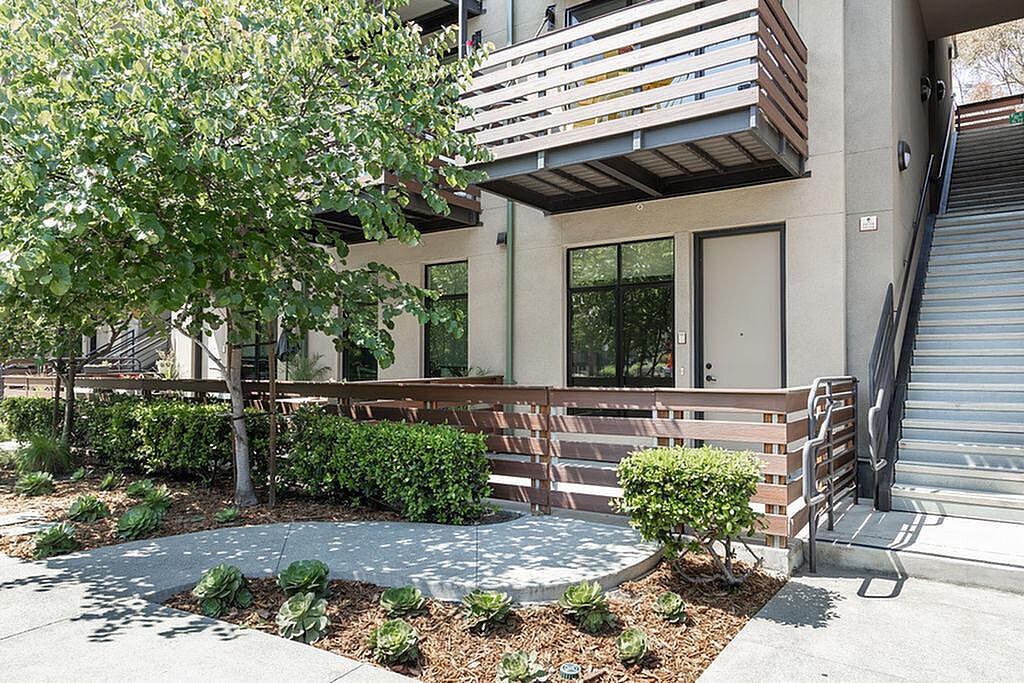 Inviting modern apartment exterior with private patio and sleek architectural design.