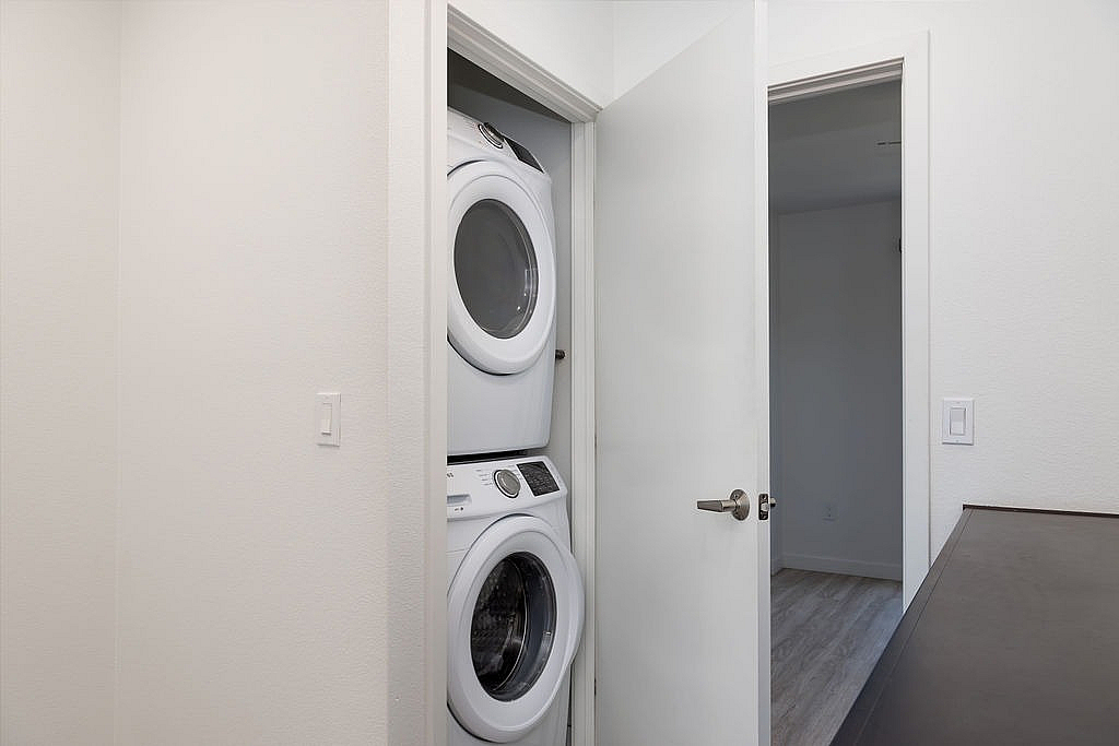 Modern apartment with a sleek, in-unit washer and dryer neatly tucked in a convenient closet space.