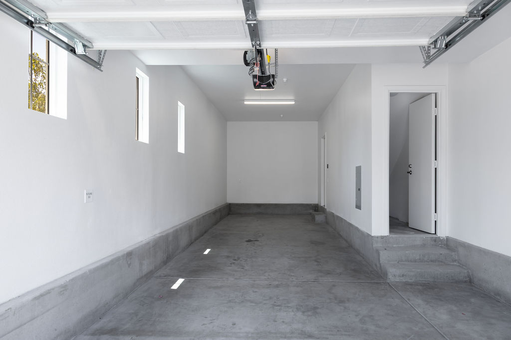 Spacious and pristine garage interior with ample room for parking and storage, featuring bright natural light through sleek windows.