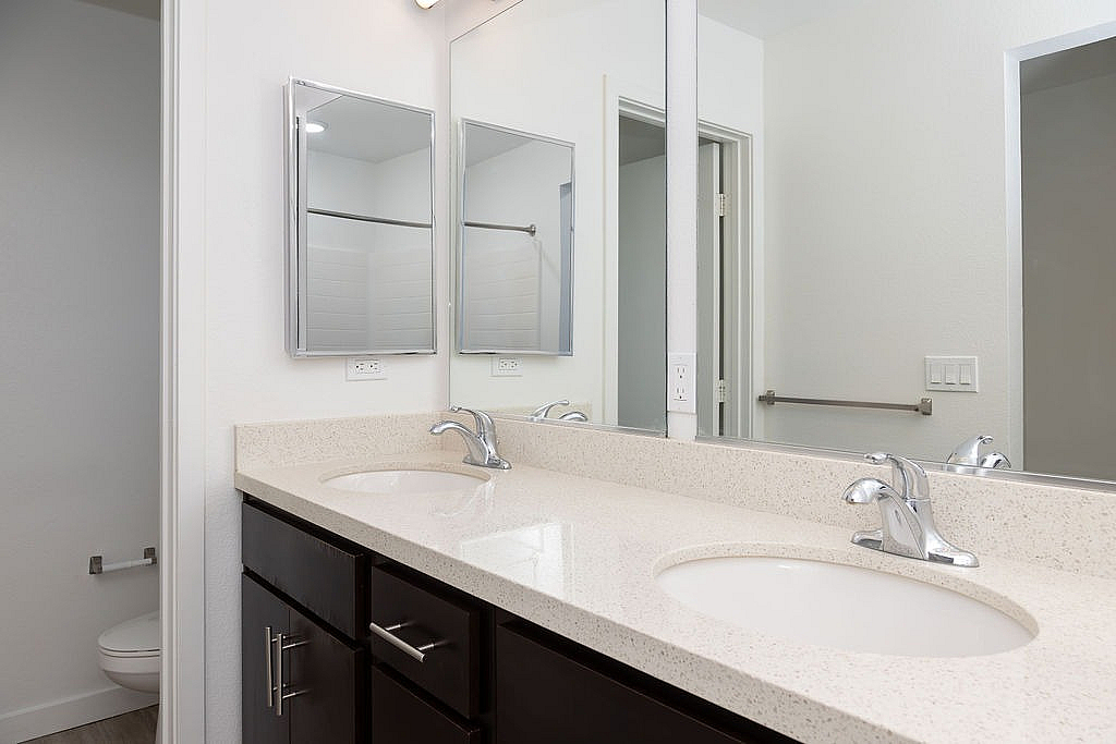 Modern bathroom with a sleek double sink vanity, elegant mirrors, and a bright, minimalist design.
