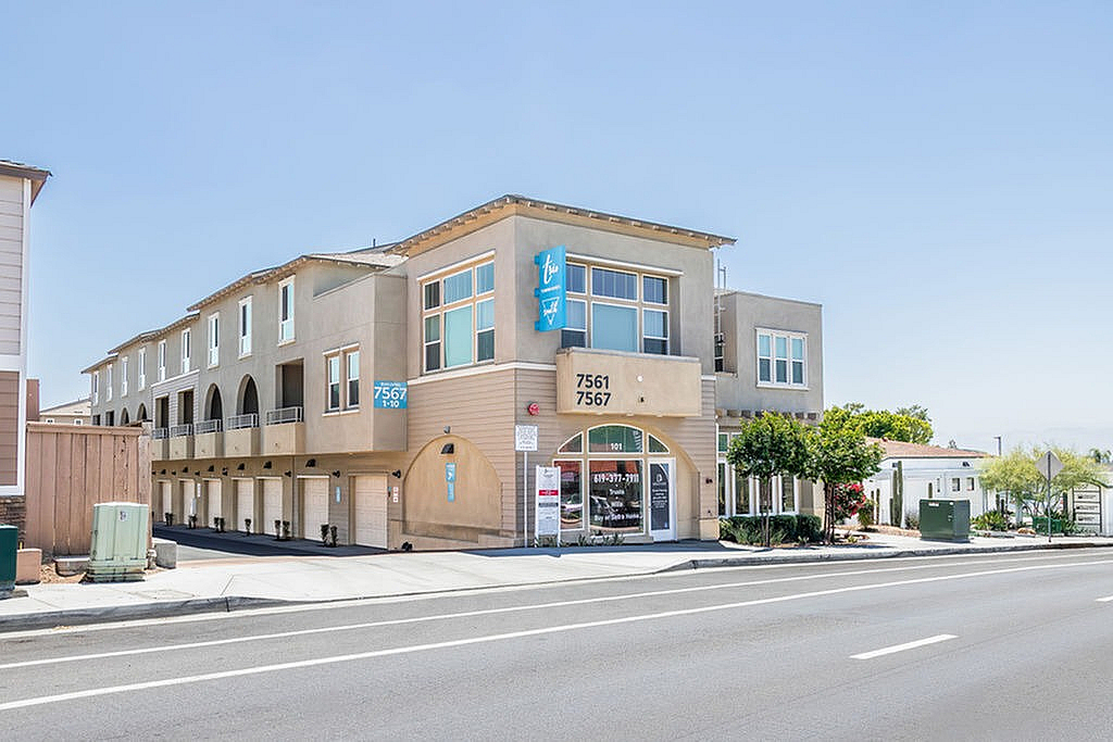 Modern multi-story townhomes for lease with elegant arches, large windows, and convenient parking, ideally located on a sunny street.
