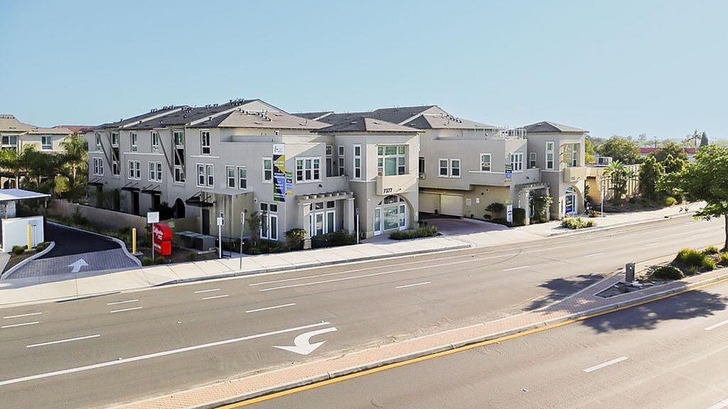 Modern townhome community with stylish architecture, offering spacious living spaces and convenient location on a sunny street.