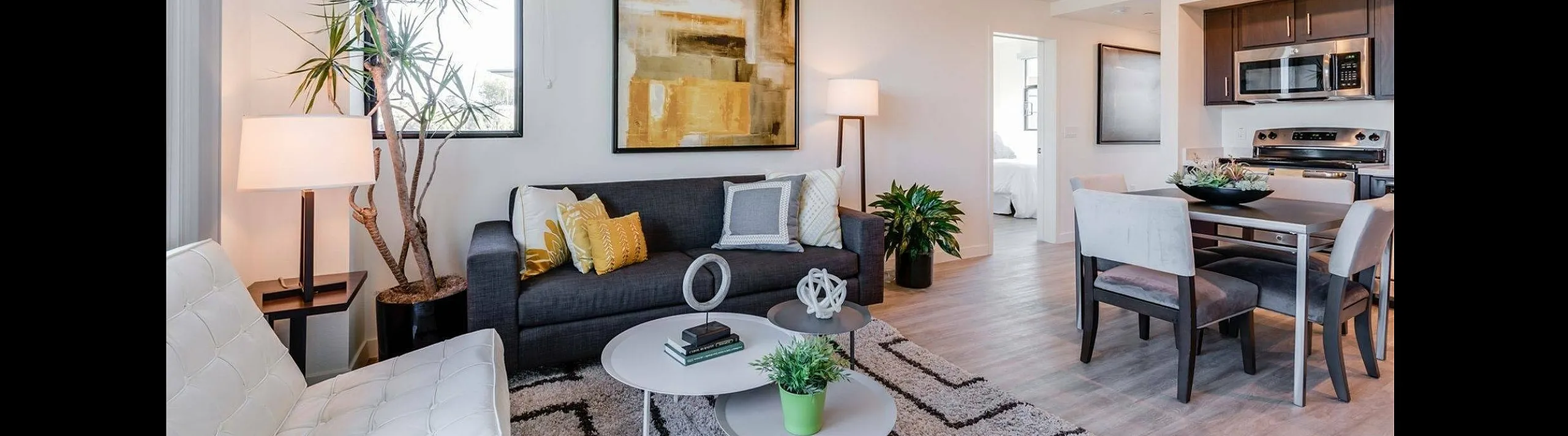 Bright and modern living room with stylish decor, comfortable seating, and an open kitchen area.
