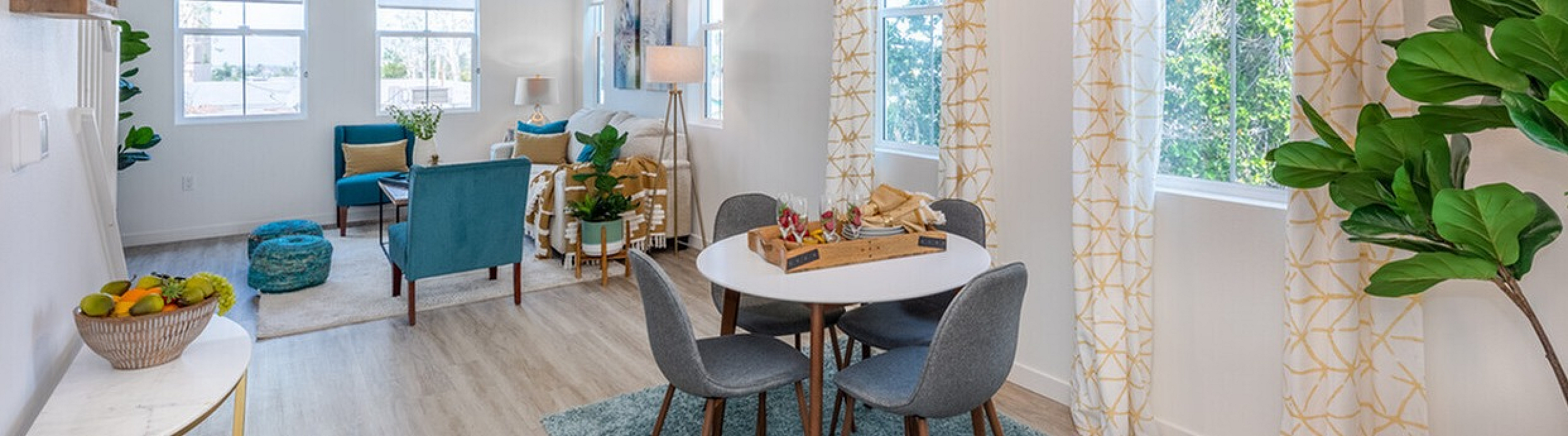 Bright and inviting living space with modern decor, featuring a cozy dining area, stylish furniture, and large windows allowing an abundance of natural light.
