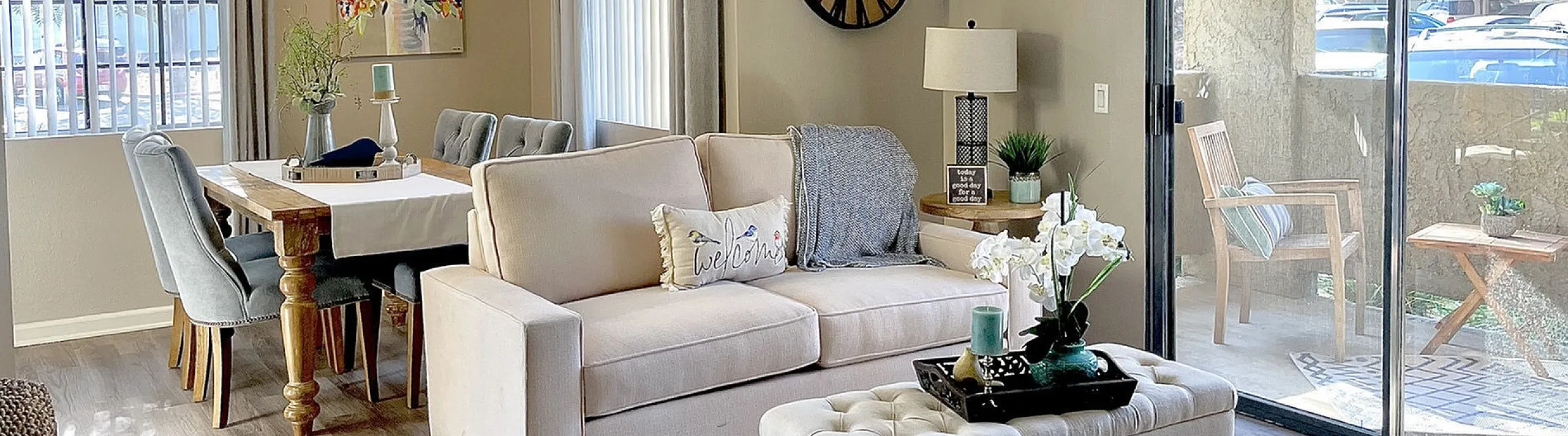 Bright and inviting living space featuring an elegant sofa, cozy dining area, and a cheerful balcony view, perfect for relaxation and entertainment.