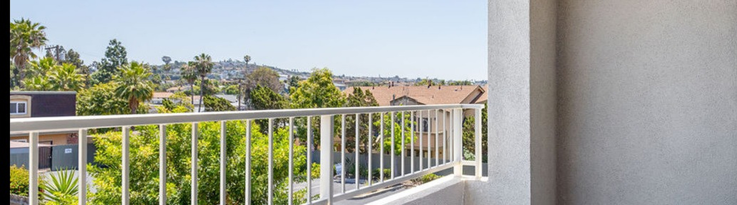 Inviting balcony with stunning panoramic views of lush greenery and distant landscape.