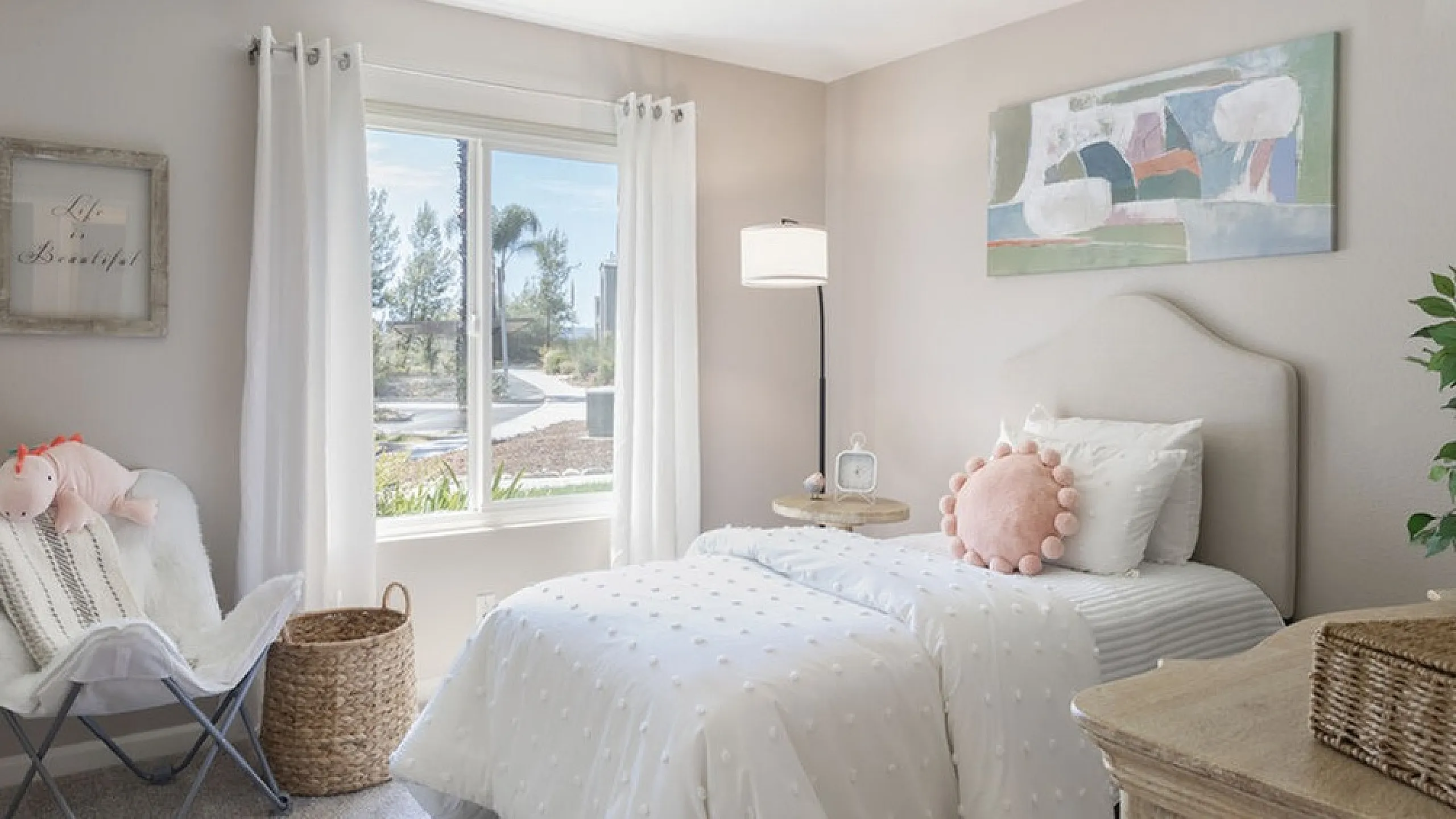 Charming bedroom with elegant decor, featuring a cozy bed, plush armchair, and bright natural light through a large window.