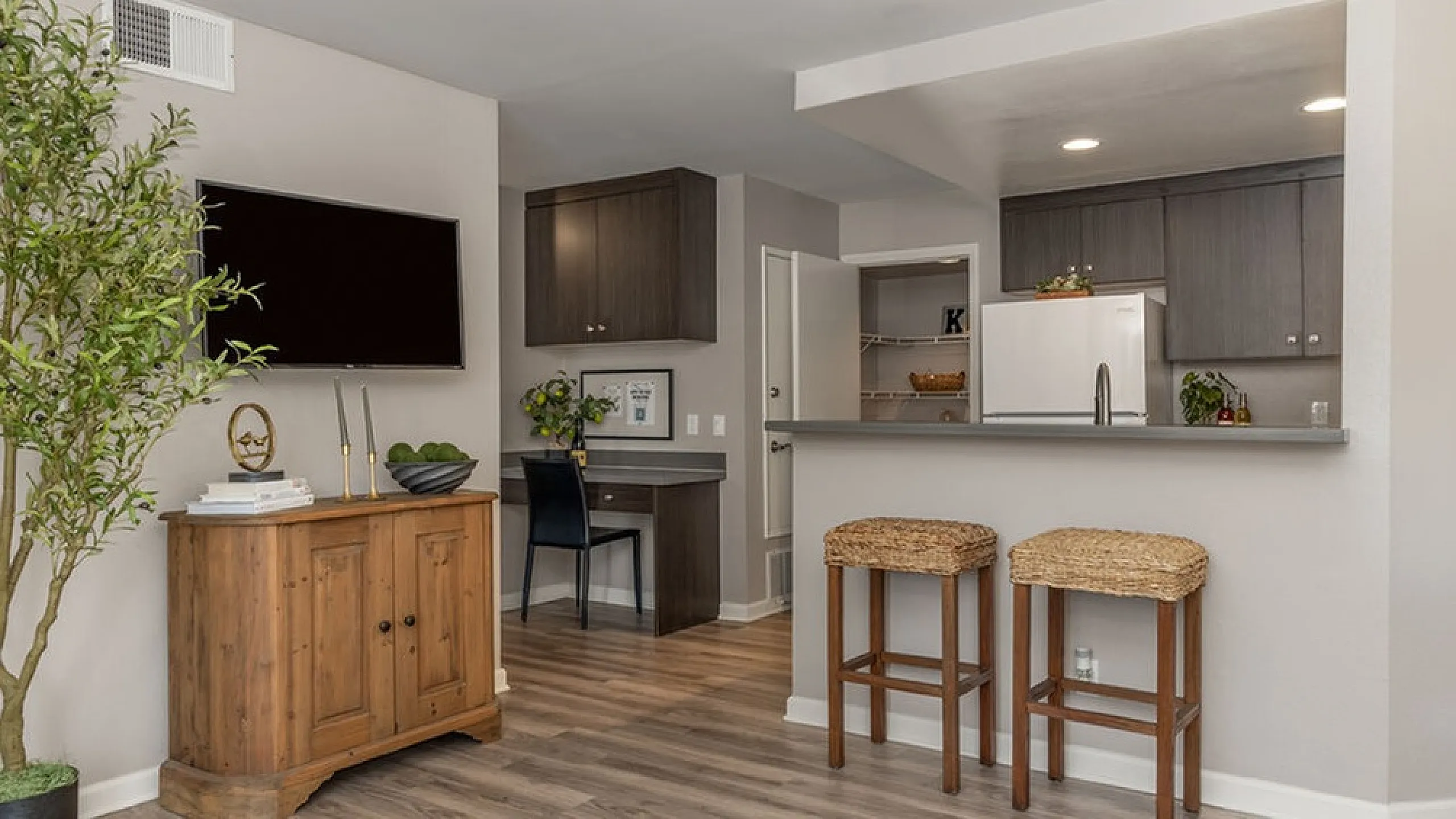 Modern open-concept living area with a stylish kitchen, cozy breakfast bar, and elegant wood flooring.