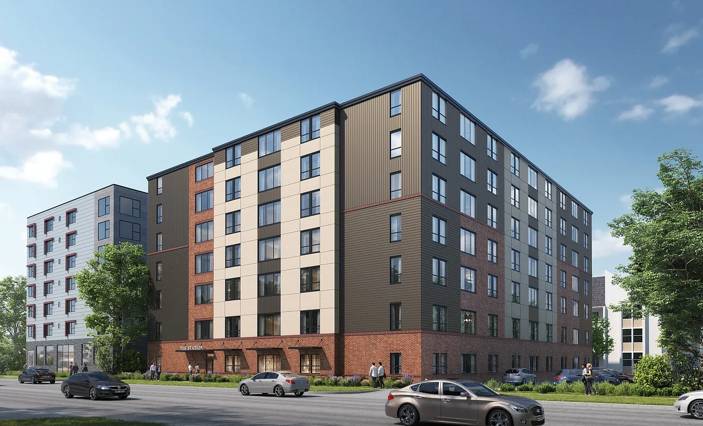 Modern multi-story apartment building with stylish brick and paneling exterior, surrounded by lush greenery and featuring large windows for natural light.
