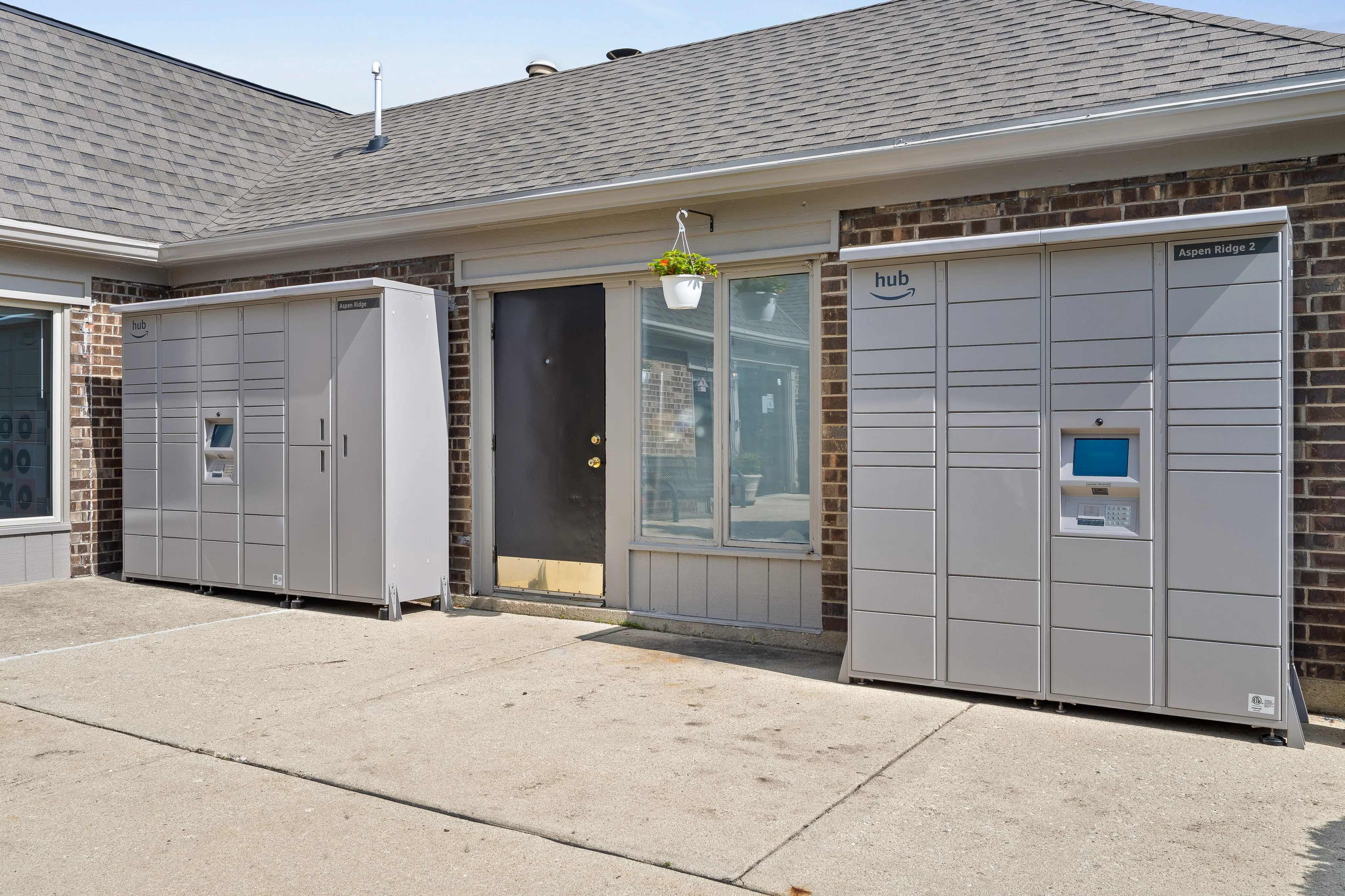 Convenient outdoor package delivery lockers in a modern apartment complex setting with hanging plant decor.