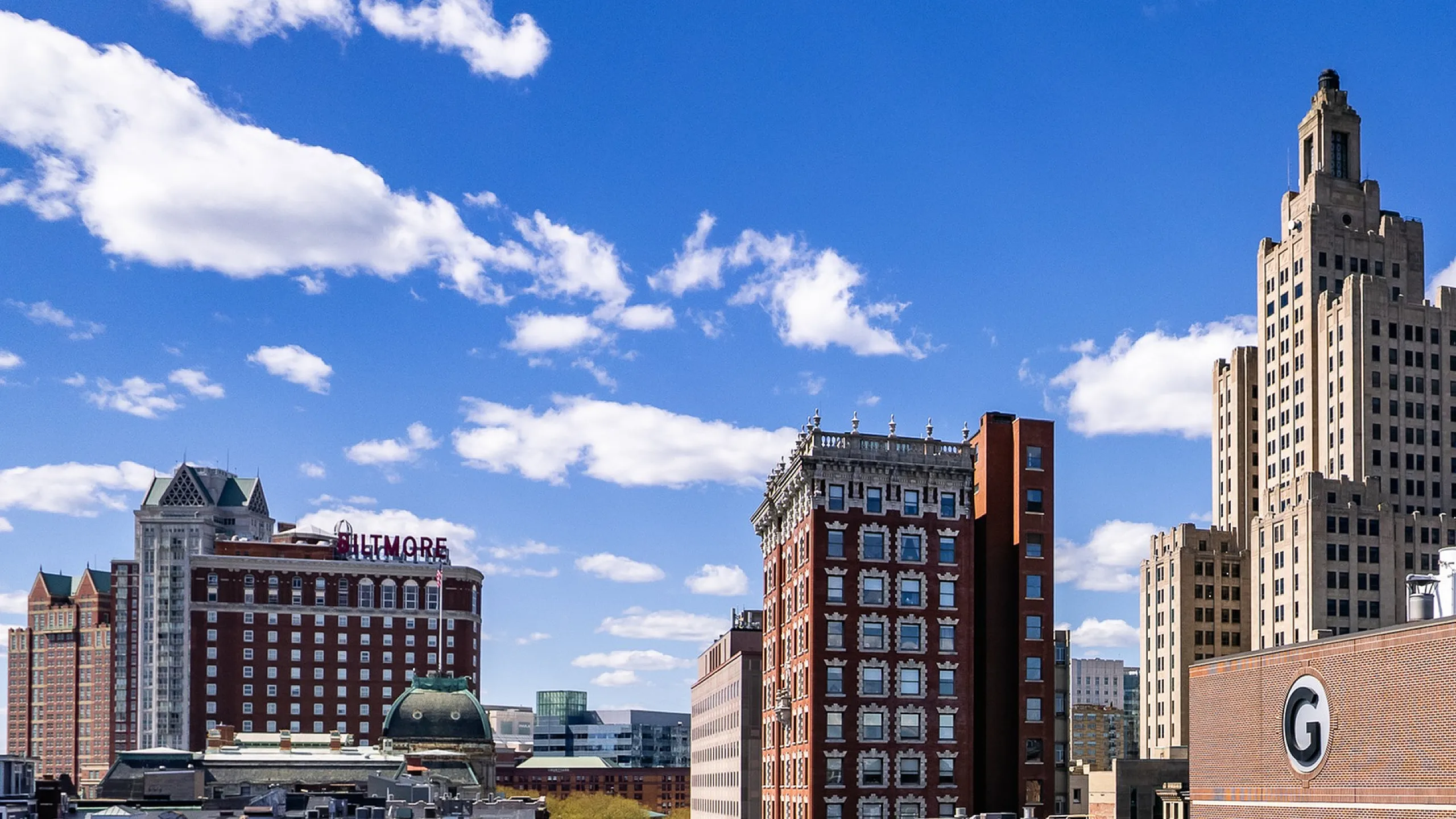 Vibrant cityscape view showcasing historic and modern architecture under a clear blue sky, perfect for urban living enthusiasts.