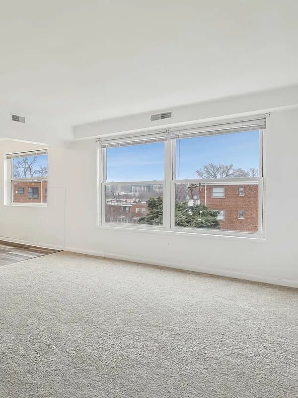 Bright living room with large windows offering a view of the cityscape and natural light.