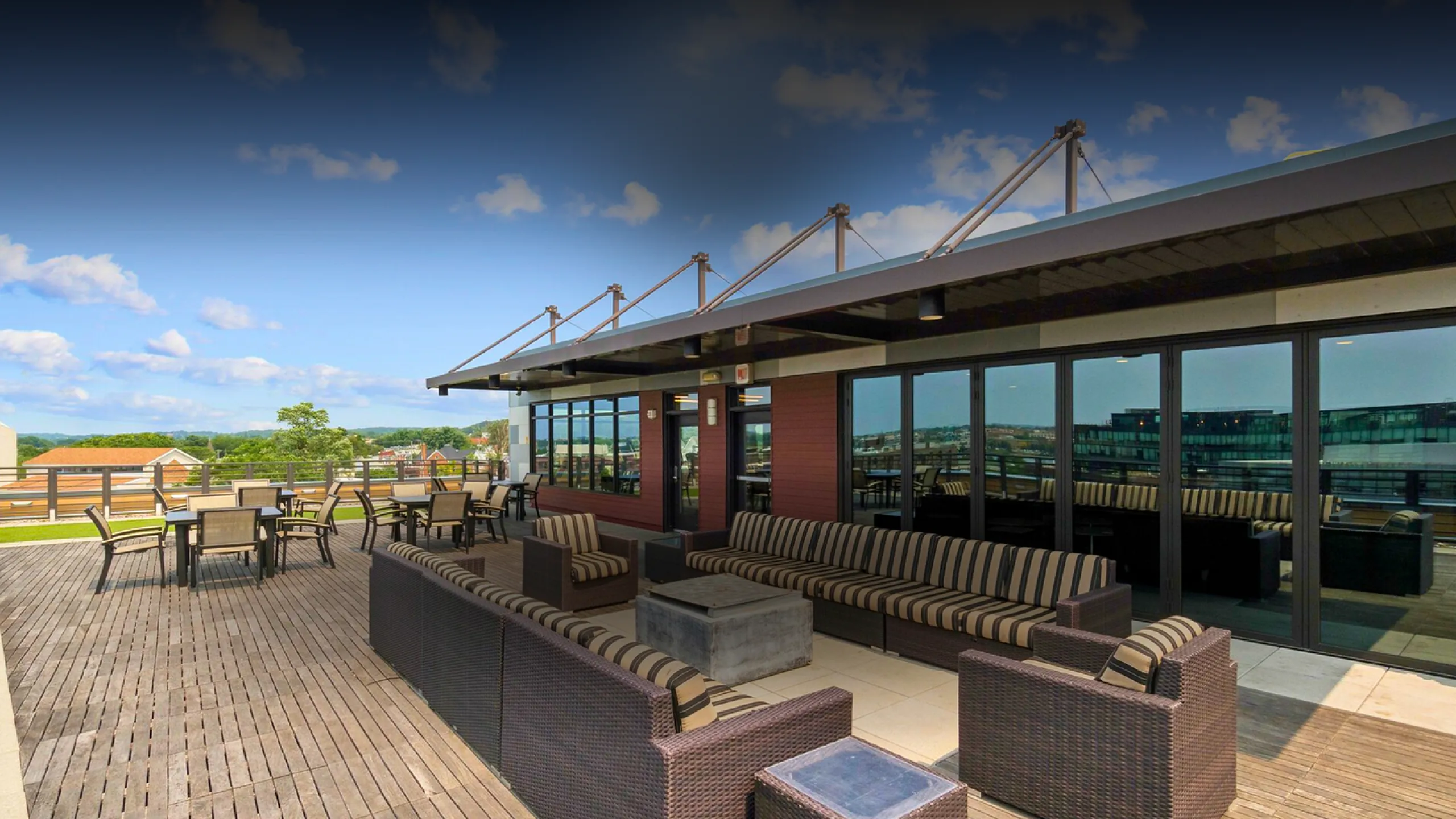 Luxurious rooftop terrace with modern seating and stunning city and sky views, perfect for outdoor gatherings.