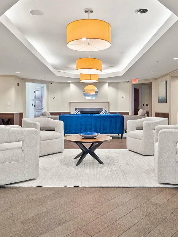 Inviting lobby area featuring elegant beige seating, modern lighting, and vibrant blue accents for a welcoming atmosphere.