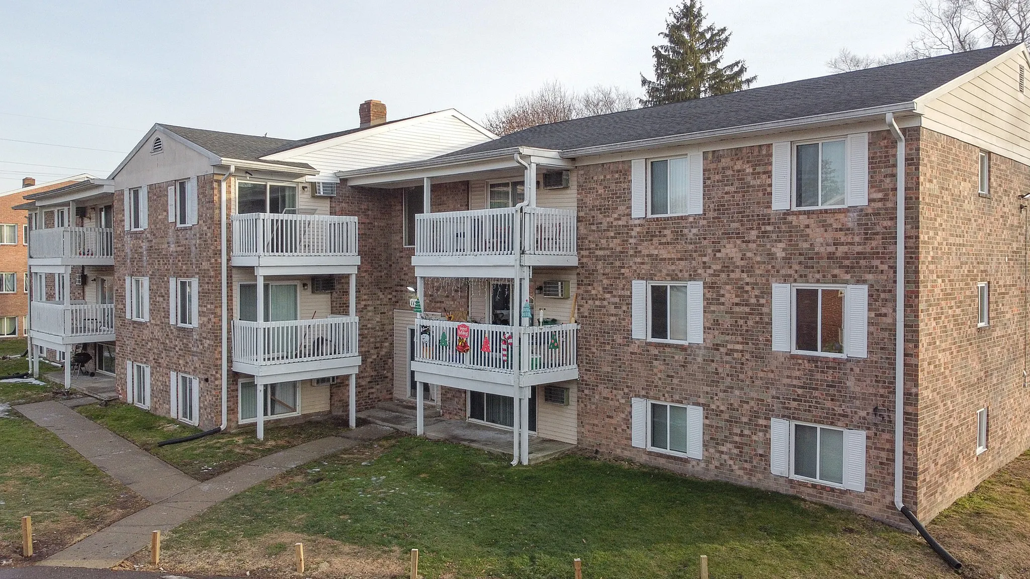 Charming brick apartment building with inviting balconies, set in a peaceful neighborhood.
